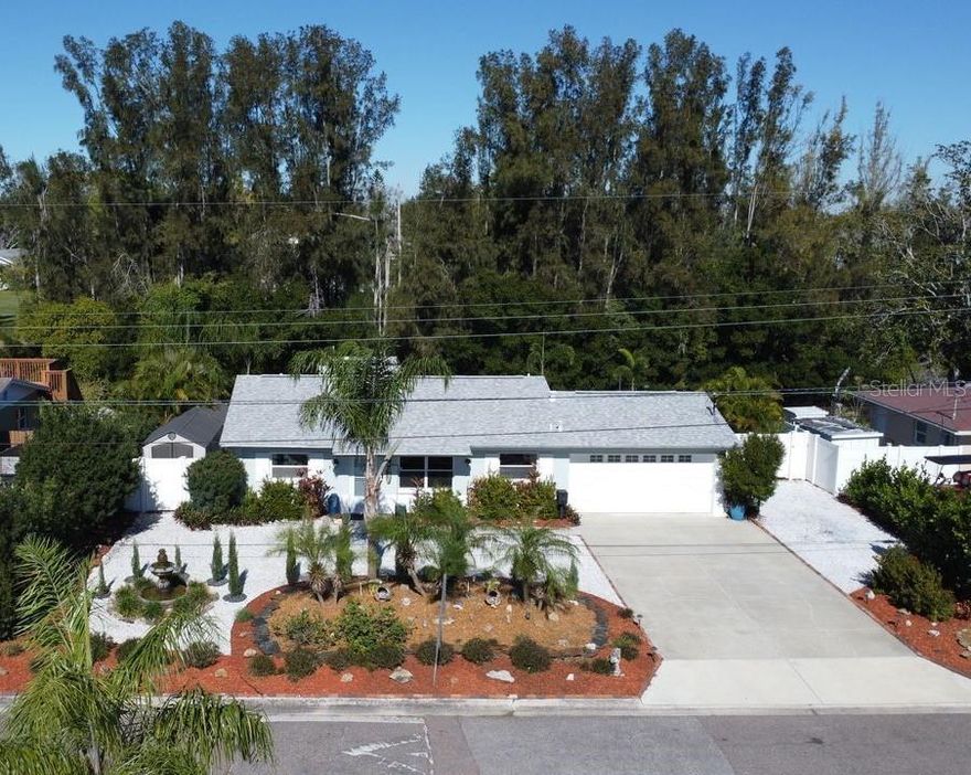 Welcome to this fully updated 2-bedroom, 2-bath waterfront home offering 87 feet of canal frontage and zero bridges to the open sea. Enjoy true ocean access and added peace of mind with a 9-foot elevation.  As you arrive, you’ll immediately notice the meticulously maintained landscaping, tranquil water fountain, and quiet street setting. Additional highlights include ample parking, designer exterior paint, a 2-car garage, updated windows, and a newer roof—all contributing to exceptional curb appeal.  Inside, the open floor plan features polished terrazzo flooring throughout most of the home, fresh interior paint, and stunning water views. The chef’s kitchen is equipped with newer stainless steel appliances, including a professional gas range with air fryer, sleek cabinetry, quartz countertops, and a large center island offering generous seating and storage. The spacious family room showcases the home’s best views and provides an ideal setting for entertaining. A large bonus flex space with a private exterior entrance—not included in the official square footage—offers excellent potential for expanded living, office, or guest space. A second full bathroom, refreshed in recent years, adds convenience. Including the garage and enclosed bonus space, the property offers 1,674 total square feet.  The primary bedroom is privately situated at the rear of the home with breathtaking water views. The en-suite bath features designer tile, shiplap accents, a spacious shower, and quartz countertops. The second bedroom is generously sized, includes built-in cabinetry, and overlooks the peaceful front yard. Step outside and experience the true highlight of this property. In 2024, a new raised seawall with span beam for a future pool, a 13,000-lb Deco boat lift with remote, and an updated dock with electric and lighting were completed. (See photos for pool renderings.) A large deck provides the perfect space for gatherings, while lush landscaping creates a private, resort-like atmosphere. Additional features include a white vinyl fence with double gate and storage sheds. Recent upgrades include a high-end tankless water heater (2024), roof and electrical panel replacement (2020), and a new air conditioner (2017). Relax with your favorite beverage as dolphins, manatees, and stingrays pass by. Walk or bike to the footbridge at the end of the street leading to the pet-friendly Rio Vista Park and Riviera Bay Park. This is a rare opportunity to own turnkey ocean-access waterfront with no bridges, backing to nature. Grab your flip-flops and start living the waterfront lifestyle you’ve been dreaming of.