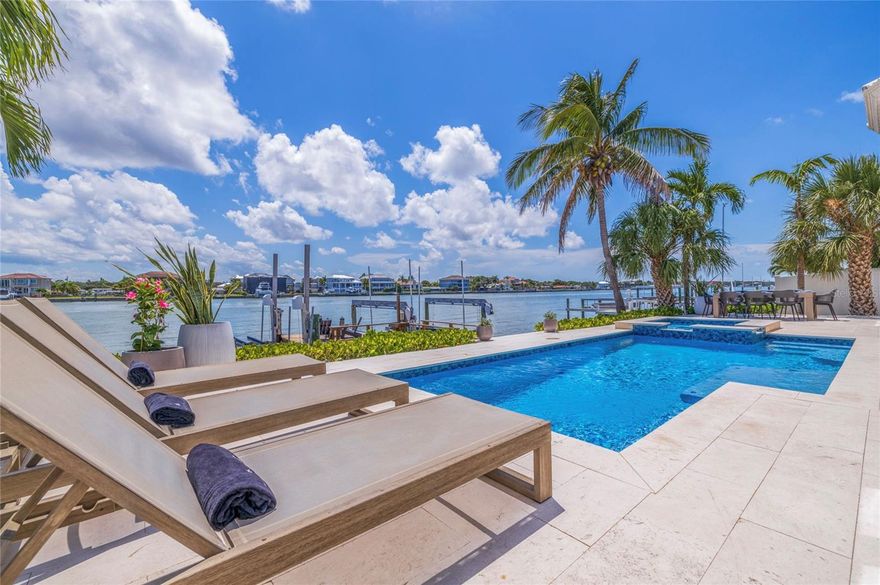 Welcome to your very own personal paradise! This exquisite coastal home is nestled on a deep-water access intercoastal waterfront lot offering the ultimate waterfront living experience. This block construction home exudes elegance and sophistication at every turn. Step inside and be greeted by a beautifully updated interior featuring a split-bedroom floor plan perfect for entertaining. The island-style kitchen is a chef's dream complete with a breakfast bar, stainless-steel appliances, marble backsplash, Quartz countertops, two-tone custom cabinets, gas range, and a pantry. The spacious Great Room boasts vaulted ceilings reaching approximately 11 feet and an electric fireplace, creating a warm and inviting atmosphere. Enjoy meals in the formal dining room, which overlooks a landscaped courtyard entry, or relax in the Florida room offering panoramic water views and a convenient dry bar. The oversized owner's suite is a true retreat featuring dual vanities, dual closets, a built-in makeup station, and a spiral staircase that leads to a second-floor bonus office/den/library with a wine bar, all overlooking the pristine intercoastal waterways. Step outside onto the Travertine paver lanai where you'll find a spill-over spa and pool perfect for soaking up the Florida sunshine. The expansive wooden dock is equipped with an electric boat lift, two jet-ski lifts, and a fish cleaning station, making it a boater's paradise. The updated vinyl seawall with an extra-wide concrete cap is ideal for fishing enthusiasts. Additional features of this remarkable home include a circular driveway for ample off-street parking, a tranquil cul-de-sac street, a 2-car garage, a tile roof, custom lighting, security cameras, dual HVAC units, vinyl fencing, an irrigation system, recessed lighting, impact-resistant sliding doors, lush landscaping, and plenty of storage space. Conveniently located just minutes away from miles of white-sand beaches, parks, nature preserves, playgrounds, shopping centers, marinas, boat ramps, golf courses, hospitals, schools, and an array of restaurants, this home offers the perfect blend of luxury and convenience. Property can be sold turnkey or vacant at closing. Furniture is negotiable. Seller is currently operating as a fully managed short-term rental. The current Property Manager would love to remain under management should a new owner desire a seamless transition. Don't miss this opportunity to start living the waterfront lifestyle you've always dreamed of today. Make this coastal masterpiece your new home!