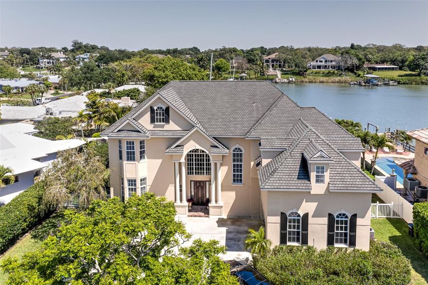 This gorgeous waterfront 7 bedroom, 5.5 bathroom pool home is located in the sought-after Harbor Bluffs neighborhood. The truly unique neighborhood offers unparalleled convenience with restaurants, a short distance to the beach, boat ramps, parks, Publix, and more right at your disposal. This magnificent 2 story home welcomes you with a large circle driveway, traditional architecture, and thriving landscaping. As soon as you enter the front door you are greeted with a large, airy, open floor plan with 22' ceilings, a double-sided fireplace, and windows along the entire back of the home for an amazing water view. The main living area boasts a large family room, living room, master bedroom, 2 guest rooms (one is currently used as an office), 2.5 bathrooms, eat-in breakfast nook, and kitchen with top-of-the-line appliances including a 6 burner gas range, double ovens, wine fridge, custom cabinetry, and more. The second story features an elegant stairway with a master bedroom designed with luxury in mind - a wet bar, steam shower, double sinks, soaking jet tub, two custom master closets, a large walk-out balcony overlooking the water, and multi-million dollar homes. Also located on the second level are 3 spacious additional bedrooms and 2 bathrooms. The outdoor living space is designed with entertainment in mind. Dual-sided fireplace, tv, and sitting area are perfect for year-round outdoor fun as well as a large pool, and spa. The dock is equipped with a 10,000 lb. boat lift and a double jet ski lift. Enjoy watching the sunrise or fishing off the spacious dock. This home and neighborhood are a must-see. Heading out for a morning run, golf carting to breakfast, hitting the beach, or heading to dinner on the boat this community offers it all. This home is the true full package!