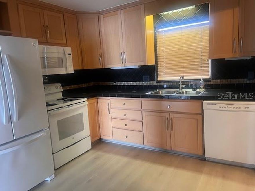 If you have been searching for a waterfront condo that actually Lives like a home, this is the one. Encompassing nearly 1.900 square feet, this beautifully maintained residence offers the comfort, scale and flexibility rarely found in condominium living. The layout feels intentional from the moment you enter, with expansive living spaces, natural light though out, and water views that instantly calm the place of your day.  The owner’s suite is generously proportioned and thoughtfully designed, complete with a spacious walk-in closet and an ensuite bath. A dedicated workspace, media room, den or additional sleeping area, this flexible room adapts seamlessly to your needs. The main living and dining areas are open yet inviting, creating an effortless flow toward the show-stopping waterfront balcony.  This outdoor space is expansive enough for both lounge seating and full dining, making it ideal for morning coffee, sunset dinners or simply enjoying the coastal breeze and open water views. It becomes a natural extension of the home. The kitchen reflects thoughtful upgrades and functionality, featuring abundant cabinetry, quality finishes, and an inviting eat-in space perfect for casual meals or conversation while cooking.  Ample storage, two private entrances, a meticulous maintenance through out speak to the care invested into this residence.  What truly sets this apart is the balance it achieves. It feels polished yet comfortable. Spacious yet warm. Sophisticated yet easy. Located within a desirable waterfront community, you are positioned just minutes away from dining, boutique shopping, major roadways and the area’s renowned sugar-sand beaches. Only 30 minutes from Tampa Airport. Here you can enjoy tranquility without sacrificing convenience.