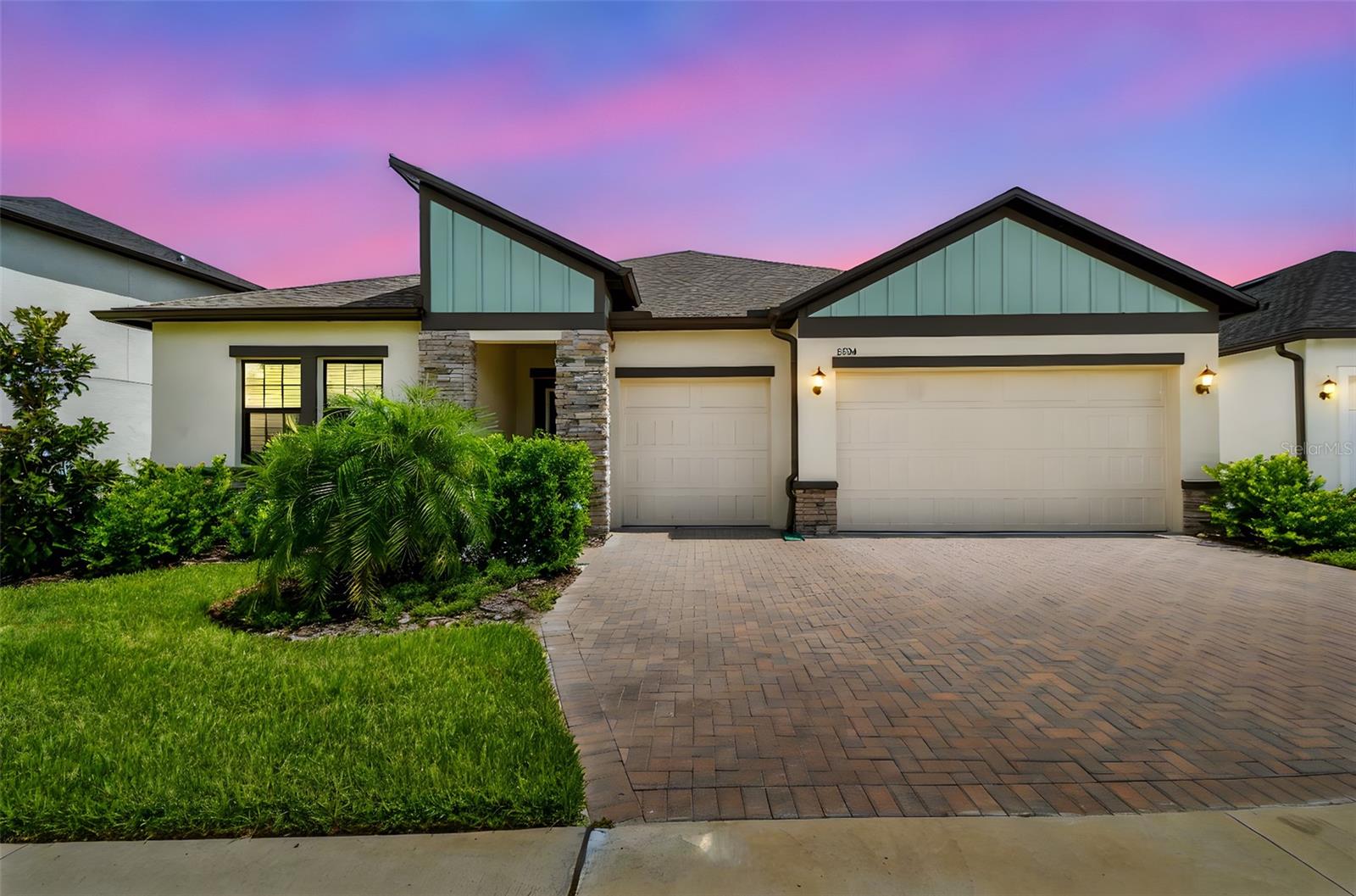 Welcome Home to Modern Elegance and Everyday Comfort
Step into this beautifully crafted, nearly new residence that perfectly blends sleek design with everyday livability. Featuring a modern-inspired exterior with a distinctive shed roofline, vertical siding, clean trim, and elegant stone accents, this home boasts stunning curb appeal from the moment you arrive.
Inside, the glass-inset front door opens to a spacious foyer that sets the tone for the thoughtful layout ahead. Just off the entry, two generously sized bedrooms share a well-appointed full bathroom—ideal for family or guests. Continue down the hallway to discover a convenient drop zone near the expansive three-car garage, as well as a large laundry room complete with a utility sink.
Tucked away for privacy, the fourth bedroom functions as a guest suite with its own ensuite bath and walk-in closet—perfect for visitors or multigenerational living.
Before entering the main living space, enjoy the stylish dry bar with built-in wood cabinetry, elegant stone countertops, and a beverage refrigerator—an entertainer’s dream.
At the heart of the home lies an expansive open-concept living and dining area that flows seamlessly into the gourmet kitchen. Sliding glass doors lead to a covered, screened-in patio overlooking a peaceful pond—perfect for relaxing evenings or weekend entertaining.
The chef's kitchen is a standout, featuring a stunning tile backsplash, a spacious walk-in pantry, and upscale finishes throughout. Whether you're hosting a dinner party or preparing a family meal, this kitchen is designed to impress and perform.
Privately located at the back of the home, the owner’s suite is a luxurious retreat, complete with a spa-inspired ensuite bathroom featuring dual vanities, a soaking tub, glass-enclosed shower, private water closet and an oversized walk-in closet.
Notable features include:
• Soaring tray ceilings
• Elegant crown molding
• 5¼” Victorian-style baseboards
• Durable ceramic tile flooring in foyer, kitchen, living areas, laundry, and all baths
• Decorative raised panel interior doors with satin nickel hardware
• Square drywall corners for a crisp, modern finish
• On-demand tankless water heater
• Whole-home water softener system
• Energy-efficient Low-E dual-pane windows
• Full gutter system
Situated in the highly sought-after Connerton community, residents enjoy an unbeatable lifestyle with resort-style amenities including scenic parks, walking and biking trails, sparkling pools, tennis and pickleball courts, a modern fitness center, and a vibrant clubhouse. Conveniently located near top-rated schools, shopping, dining, and everyday essentials.
This like-new, move-in-ready home offers the perfect combination of luxury, comfort, and community. Schedule your private tour today and make this exceptional home yours!