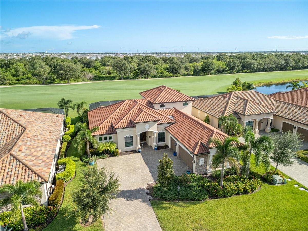 Welcome to this beautifully designed Napoli Grande model, offering over 3,000 square feet of thoughtfully planned living space. With three bedrooms, two-and-a-half baths, a downstairs den/office that easily doubles as a fourth bedroom, plus an expansive upstairs bonus room, this home provides flexibility for every lifestyle. The bonus room is a true entertainer’s retreat, featuring a full wet bar with cabinetry, a beverage fridge, and a full bath. Step outside and you’ll discover your own private oasis. A custom saltwater pool with an eight-person spa, sun shelf, and elegant spillover edges sets the stage for relaxation after a day on the course. The extended lanai offers multiple seating and dining areas along with a built-in gas grill and beverage fridge—perfect for gatherings with family and friends. Inside, you’ll find upgrades throughout, including a chef-inspired kitchen with an extended layout, lighted glass cabinets, stainless steel appliances, and gas cooking. The great room is anchored by a striking custom stone fireplace wall with shelving, cabinetry, and smart lighting—plus a TV mount that swivels so you can catch the game from inside or out. The open-concept plan also features an inviting dining area and a den with French doors, offering both privacy and versatility. This home is located in the sought-after Lakewood National Golf Club where you can enjoy all of the membership privileges including the ability to play on one of two 18 hole Arnold Palmer–designed championship golf courses. The community’s award-winning amenities include a resort-style pool with waterfalls and lap lanes, a poolside tiki bar, fitness center with classes, full-service spa, tennis, pickleball, bocce, satellite pools, and a 28,000-square-foot clubhouse with dining, lounges, and a full calendar of events. Lakewood National even plays host to the annual Korn Ferry Tour’s LECOM Suncoast Classic. All of this is nestled within Lakewood Ranch, the nation’s top-selling master-planned community, known for its dining, shopping, entertainment, top-rated schools, and proximity to world-class beaches and cultural attractions in Sarasota and beyond. Monthly rentals less than 6 months include utilities and are subject to sales and Resort Taxes (13%). Membership transfers for just $642.00 and all you pay is the cart fee!