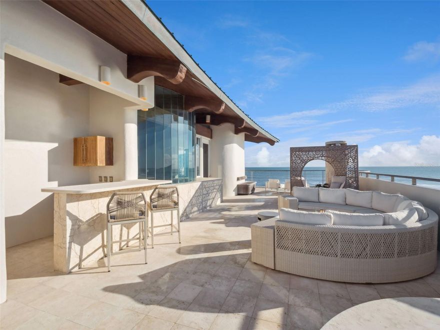 The Only One of Its Kind on New Smyrna Beach — A Four-Level Oceanfront Estate with Rooftop Terrace, Architectural Spiral Staircase, & Private Elevator

Quietly positioned along a coveted stretch of New Smyrna Beach with deeded beach access and no HOA, this architectural showpiece offers panoramic Atlantic vistas, refined coastal design, and effortless indoor-outdoor living across four levels. Crafted for privacy, entertaining, and multigenerational living, the residence pairs a sculptural open spiral staircase in natural travertine with a private elevator —culminating in an expansive rooftop terrace for sunrise coffee, sunset cocktails, and stargazing above the shoreline.

Walls of glass and multiple terraces frame sweeping ocean views while inviting soft sea breezes through the main living spaces. The thoughtful layout provides guest accommodations on the lower levels and lofted lounges above, creating separation when you want it and connection when you need it. The kitchen, dining, and gathering areas flow seamlessly to outdoor spaces designed for relaxed coastal entertaining. Morning light pours into the ocean-facing rooms; evenings are for taking in the sound of the surf and the glow of the moon on the water.

Highlights

Four-story single-family oceanfront estate

Private elevator

Sculptural open spiral staircase in natural travertine

Expansive rooftop terrace with unobstructed Atlantic views

Deeded beach access; no HOA restrictions

Coastal architecture ideal for multi-generational living

Indoor-outdoor lifestyle with multiple balconies & terraces

Approved plans and permit for a custom pool—ready for your vision

Lifestyle & Entertaining
From coffee at daybreak on the rooftop terrace to wine at dusk on the beachfront balconies, this home is purpose-built for elevated coastal living. Generous gathering areas, flexible guest suites, and abundant storage support long weekend stays and extended visits alike. With direct beach access just steps away, every day is an invitation to swim, surf, stroll, and savor one of Florida’s most beloved stretches of sand.

Location
Moments to NSB’s dining, boutiques, and vibrant art scene—and an easy drive to Orlando’s international airports and attractions—6965 S Atlantic places you close to everything while feeling a world away.