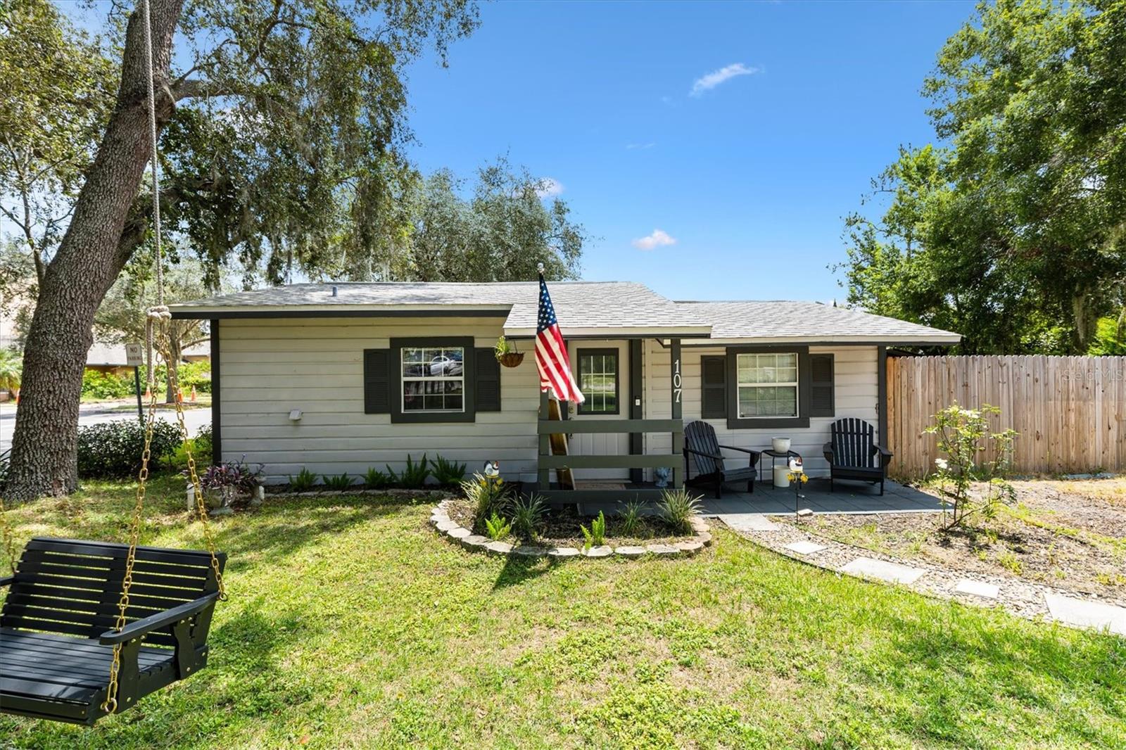 Welcome home to this cozy and beautifully maintained 1BR/1BA cottage-style home with a DEN/OFFICE, nestled in the heart of Lady Lake. Perfectly blending charm and comfort, this residence sits on an oversized 0.24-acre corner lot with no HOA and no deed restrictions—giving you freedom and flexibility. With recent improvements such as a new AC(2024), roof(2021), septic(2022), and much more, you can rest assured for years to come. From the moment you arrive, you’ll be greeted by inviting curb appeal, complete with a classic front porch and a charming hanging swing. Inside, you’ll find a warm and welcoming interior featuring rustic wood accents, tile flooring throughout, and a thoughtfully designed open layout. The living room flows seamlessly into the kitchen, creating a functional space ideal for both relaxing and entertaining. The kitchen boasts white cabinetry, ample counter space, and a charming breakfast bar—perfect for casual meals or morning coffee. The updated bathroom offers modern finishes, while the spacious bedroom is filled with natural light and offers generous storage. There’s also a versatile den/office space to suit your lifestyle needs. Step outside to your private, fenced backyard—ideal for pets, gardening, or hosting outdoor gatherings. The yard also includes a large shed and a covered patio area perfect for grilling and entertaining. Whether you're a first-time buyer, downsizing, or looking for a rental investment, this home is a rare gem. Don’t miss your opportunity to own a unique slice of Florida charm—schedule your showing today!