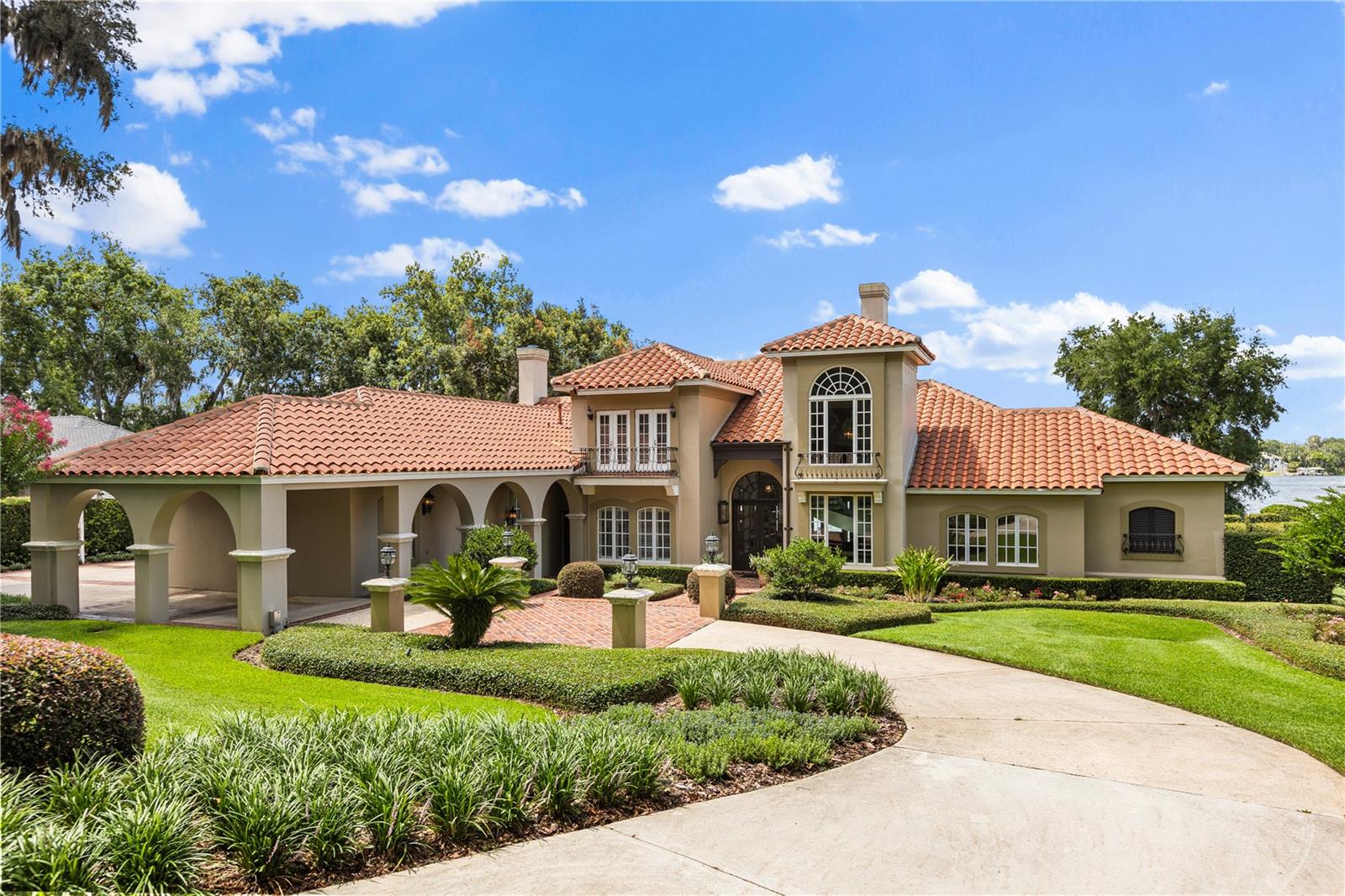 A rare opportunity to own one of the most distinguished lakefront estates on Lake Brantley, Central Florida’s premier private, sand-bottom ski lake. This custom-built estate spans 4,956 square feet, featuring 4 spacious bedrooms, 5.5 baths, a private library, wine cellar/basement, and an oversized three-car garage with a stately porte-cochere. Gas lanterns invite you beyond custom mahogany entrance doors to soaring 20-foot ceilings and expansive lake vistas. Two wood-burning masonry fireplaces, and a wealth of architectural details—extensive use of St. Louis brick, hand-scraped hard-wood flooring, and artesian crafted wrought iron throughout. The open-air pool and spa, fully equipped summer kitchen, and lush lawn unfold onto a private sandy beach where you can even build a sandcastle. A private dock with boat lift invites boating, skiing, or simply taking in the peaceful lake views. As twilight falls, the estate comes alive with a complete landscape lighting package, setting the scene for evening entertaining or tranquil nights under the stars. This luxury home is situated on 1.25 acres with flawless landscaping. This architectural masterpiece embodies refined relaxation right in the heart of Longwood - one of Seminole County’s most established and sought-after communities. Known for its A-rated schools, tree-lined streets, and timeless appeal, Longwood offers the perfect blend of tranquility, prestige, and convenience, with quick access to boutique shopping, upscale dining, major highways, and Orlando’s top employers. This is more than a home—it’s a one-of-a-kind legacy property that offers elegance, privacy, and Lake Brantley living at its finest.