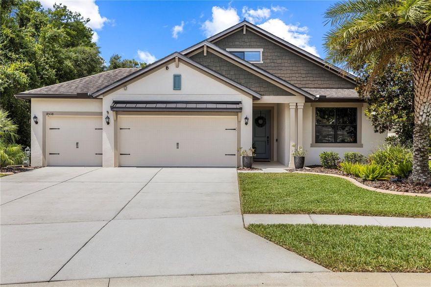 Welcome to 8538 May Port Court in Land O’ Lakes, Florida, a beautifully upgraded 4-bedroom, 3-bathroom pool home with a 3-car garage located on an oversized cul-de-sac lot with pond and conservation views in the gated community of Lakeshore Ranch. This move-in-ready home features a desirable 3-way split floor plan designed for both privacy and functionality with an upstairs bedroom and full bath that works perfectly as a guest suite, home office, or bonus room. Inside, you’ll find high ceilings, natural light, custom woodwork, stylish accent walls, barn doors, built-ins, and an open layout ideal for entertaining. The updated kitchen overlooks the family room and showcases granite countertops, stainless steel appliances, a gas range, a beverage refrigerator, a brick-pattern stone backsplash, updated cabinetry, and a built-in coffee bar/workstation. The spacious family room features custom built-ins, a shiplap accent wall, an electric fireplace, and a dry bar with rustic shelving. The primary suite offers pool views, a sitting area, a walk-in closet, and an updated en-suite bathroom with dual vanities, granite counters, and a large walk-in shower. Step outside to your private backyard oasis complete with upgraded pavers, a custom outdoor kitchen with gas grill and bar seating, and a gas-heated pool perfect for year-round Florida living. Additional features include fresh interior paint, built-in speakers, a water softener, a security system, a utility sink, pull-down attic stairs, a newer dishwasher, and pride of ownership throughout. Residents of Lakeshore Ranch enjoy resort-style amenities including a 24-hour guard gate, clubhouse, multiple pools, fitness center, fishing dock, dog park, playground, tennis, pickleball, basketball courts, and community events. HOA includes cable, internet, and trash service.