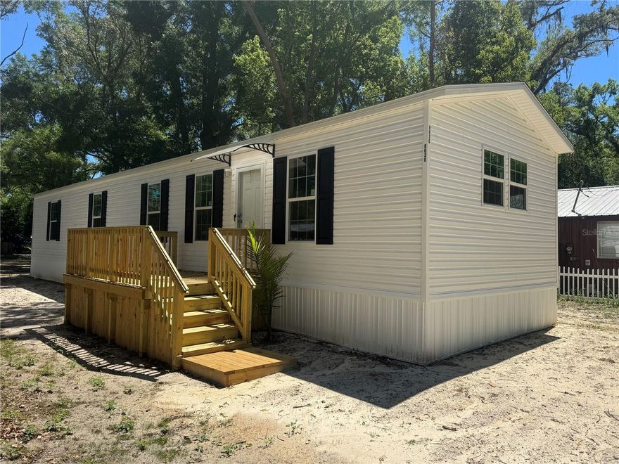 Welcome to affordable, turnkey living in the heart of Gilchrist County. Situated on a freshly cleared quarter-acre lot, this brand-new 2026 single-wide with 8' ceilings offers the rare combination of new construction feel, upgraded finishes, and fully completed infrastructure so buyers can move in and enjoy without the usual setup headaches.

From the moment you arrive, the value is clear: brand-new well, brand-new septic, brand-new power pole, brand-new porches, and a brand-new home already in place. Inside, this thoughtfully upgraded home stands out with 8-foot ceilings, a feature that gives the space a more open, house-like feel, along with a professionally finished custom accent wall in the living room that adds warmth and style. The kitchen is equipped with upgraded stainless steel appliances, including a stainless refrigerator and range, creating a clean and modern look that elevates the entire home.

Beautifully finished and move-in ready, this property offers a low-hassle ownership opportunity that can be hard to find at this price point. Located in a convenient Trenton area setting with access to shopping, dining, and everyday needs, this home also benefits from reasonable Gilchrist County taxes, A-rated schools, and the strong sense of community that makes this area so appealing.

If you have been searching for a fresh start, a low-maintenance home, or an affordable property where everything is already done for you, this one deserves a look. Power will be on this week with certificate of occupancy issued.