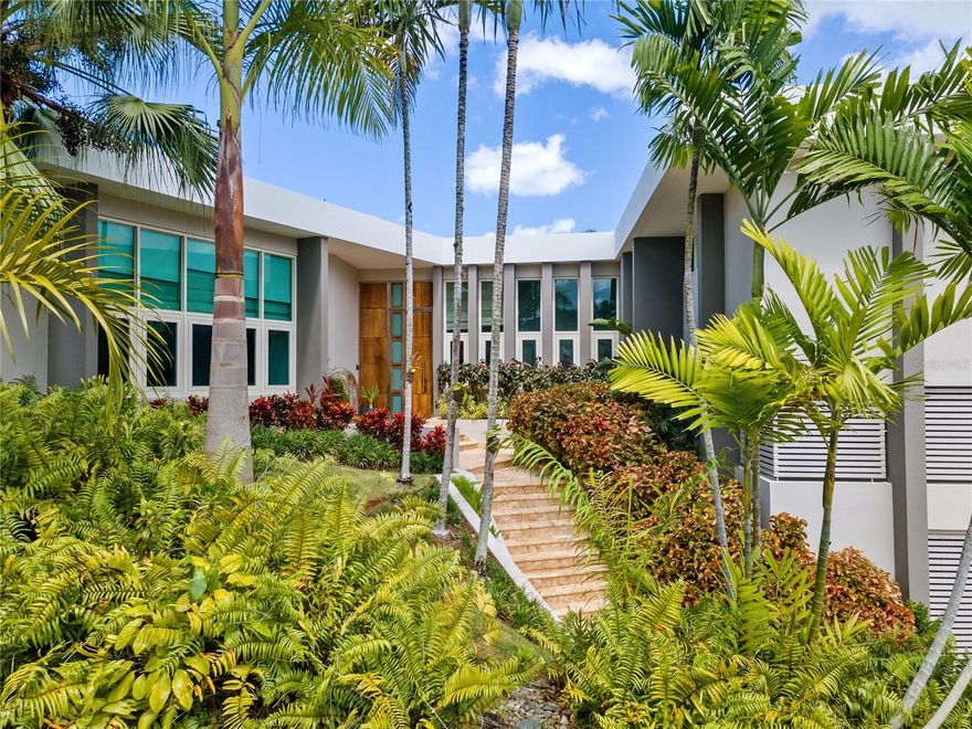 Welcome to a contemporary architectural gem, discreetly nestled on a private cul-de-sac in the coveted Garden Hills neighborhood of Guaynabo. This expansive property situated within a generous 1,245 square meter lot, showcases a home that embodies resort elegance and tranquility, offering an impressive 4,100 square feet of living space.

This retreat exudes an ambiance of privacy and relaxation, thoughtfully designed across three levels, offering 4 bedrooms, 4 full baths, 2 half baths, a home office, and a guest studio apartment.

Upon entry, the main level impresses with its skylight-adorned foyer, revealing a spacious living room that opens to an interior patio. The well-appointed open kitchen, with its brilliant design, granite countertops, modern appliances, and ample cabinetry, effortlessly connects to the formal dining room, family room, home office, and a powder room. 

From the dining area and kitchen there is a continuous transition to the expansive outdoor terraces, where one can appreciate sweeping views of the lush and verdant landscape offered by its natural surroundings. A spacious kitchen and dining area with folding glass windows lead to an inviting terrace that overlooks a striking waterfall, pool and patio.

The residence features refined marble floors, recessed lighting, and an air of sophistication that characterizes each space. Floor-to-ceiling windows accentuate the spacious and bright rooms. Abundant natural light gracefully illuminates every corner of the residence, creating a warm and peaceful ambiance from the moment you step in. Boasting a cascade-style pool, a tranquil koi pond, an exterior dining area, wet bar, barbecue grill, and a spacious covered terrace, the home offers an enviable outdoor oasis meticulously designed for seamless entertaining.

The property caters to a discerning crowd with an appreciation for design seeking relaxed resort living. By effortlessly integrating the surrounding natural beauty into its architectural design, this home is ideal for hosting grand-scale gatherings. 

Notable equipment included with the purchase: central air conditioning, 5 inverter units, a solar water heater, 400 galons cistern, a 45K power generator, and ample storage closets.

Garden Hills Sur is recognized as a premier community within Guaynabo, offering one of Puerto Rico's most sought-after locations. Located just 15 minutes from San Juan, this community offers private access for residents to Torrimar Park, sports center that features baseball and soccer fields, along with basketball and tennis courts. Adjacent to Baldwin School and in proximity to numerous shopping venues, including the renowned San Patricio Plaza, this residence harmoniously balances suburban comfort with the conveniences of city living.

Discover a lifestyle of unparalleled refinement in this Garden Hills masterpiece—a contemporary sanctuary where elegance, space, and natural beauty converge to create a truly exceptional living experience.

 (Property also available for Rent - $13,000.00)