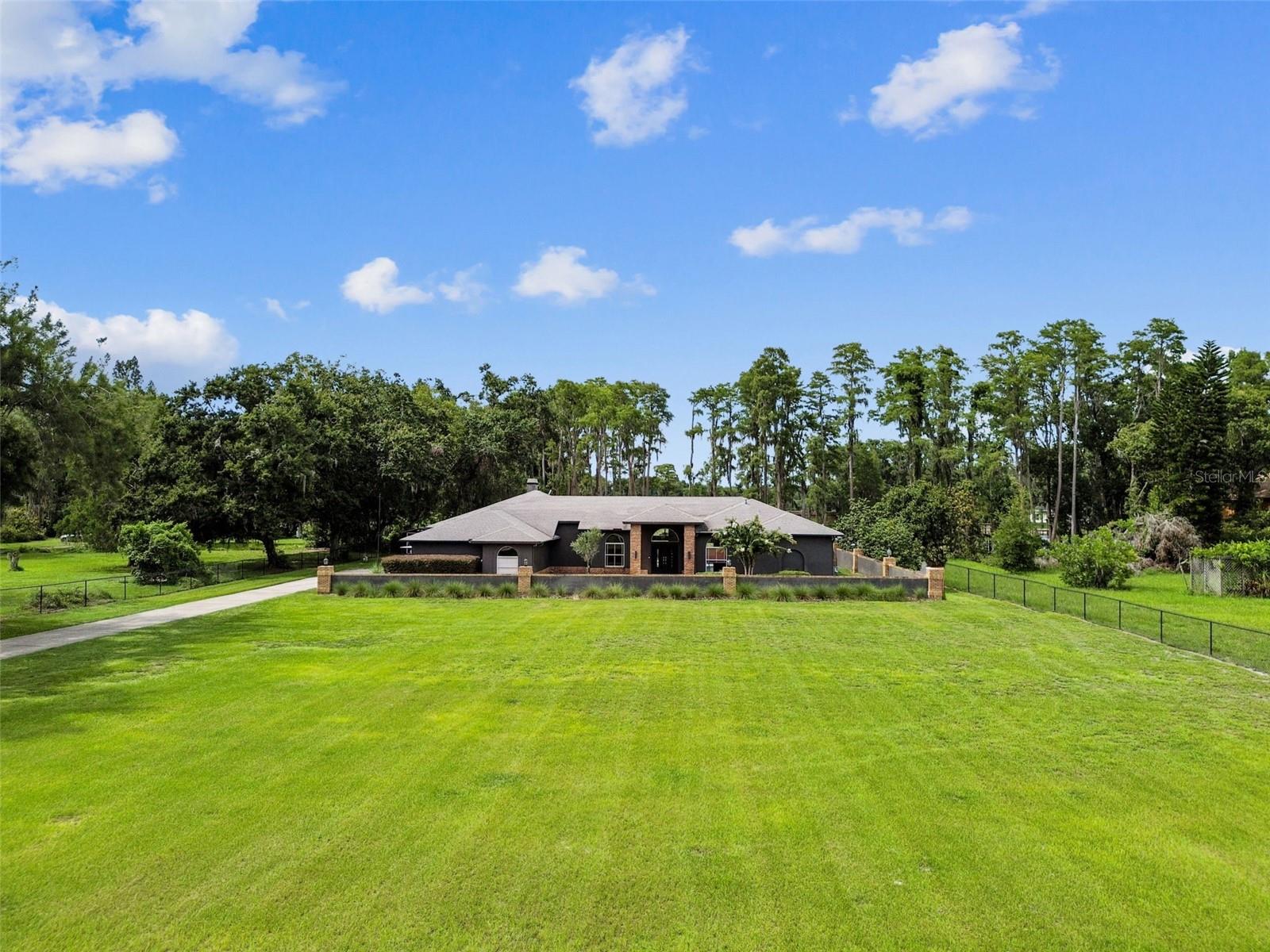 Welcome to Your Dream Lakefront Property! This beautiful 4 bedroom, 4 bathroom home features high ceilings and a chef’s kitchen with a gas stove, double ovens, and a beautiful window over the kitchen sink letting the natural light in as well as providing a gorgeous view of the lake. Enjoy the indoor-outdoor living with 3 sets of pocket sliding doors all leading to a private pool and lanai with a very picturesque setting and breath taking lake view. This home is thoughtfully enhanced with a large seating area in the main suite, creating a serene backdrop for relaxation. You'll also appreciate the unique built-in cabinet with shelving in the family room as well as the custom closet in one of the secondary bedrooms. With a large lot and ample space, there's plenty of room for family activities and entertaining. Plus, this home is on the famous 4th of July parade route! The property has beautiful grass and features a custom chicken coop, an electric gate, and is gated and fenced all around for privacy and security. Additionally, a large shed provides extra storage space for outdoor equipment, tools, or hobbies. For the boating enthusiast, there's a covered dock with a boat lift on Little Lake Hobbs with direct access to Lake Hobbs—a large ski lake tailored for adventures and peaceful retreats alike. With its unbeatable location, you're just a 30-minute drive to Tampa International Airport and close to all the vibrant amenities, restaurants, and popular spots Tampa Bay has to offer. Families looking to live on a lake or anyone ready to embrace the beauty and tranquility of lakefront living, this property is the opportunity you’ve been waiting for! Come experience the serenity and excitement of lakefront living for yourself – schedule a showing today and make this incredible property yours!