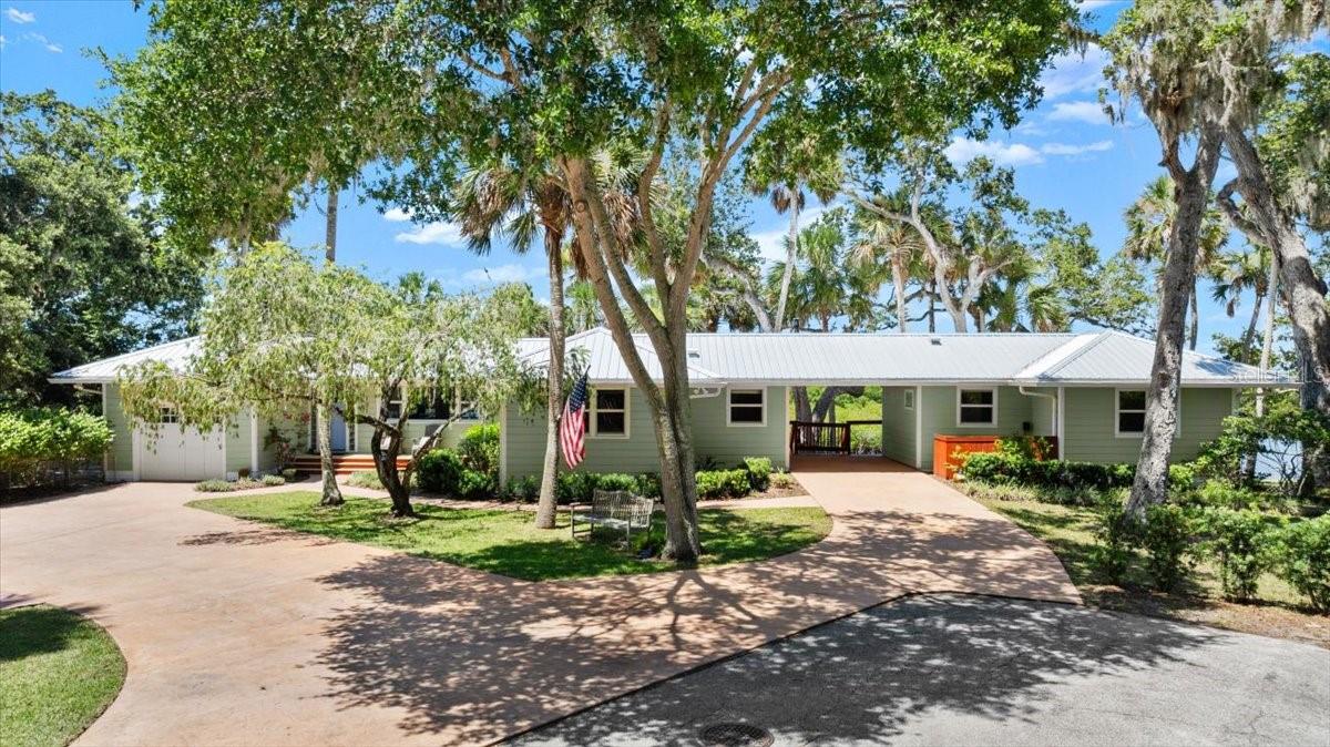 Wow! What a view - from Ponce Inlet light house to Diamond Head! This fully renovated waterfront estate, designed by renowned Architect Kevin Schweizer, is in the heart of New Smyrna Beach and waiting for you to call it home. Nestled under historic oaks on +- .65 acres, this private residence stretches along 214 feet of water frontage with only Mother Nature’s stunning views as your eastern neighbor. Dolphins, manatees, sea turtles and shore birds visit daily. The main home was originally built in 1949 but was gutted and completely rebuilt with all
new electric, plumbing, insulation and finishes in 2012. It offers 2 bedroom suites, original milled cedar siding, heart pine wood floors and interior doors, a one car garage, and PGT impact windows looking out over the water from an open floor plan living room, dining room and kitchen. A private screened porch off the master bedroom and a newly built approx. 750 sq ft three level deck with gas lines for grilling and an outdoor fire pit provide additional outdoor living space. A separate but attached in-law suite/art studio/guest home was built in 2012 and
includes a comfortable bedroom, bathroom, kitchenette and living room along with its own carport and covered porch with water views. In 2020, an oversized 24x24 detached garage was built for all those toys. A 24 gauge metal roof was also installed in 2020 on all structures. Enjoy sunning on the deck or walk a few steps down to the screened boathouse and concrete boat slip set along the waterfront. Feel the breeze and throw a line in the water. Better yet - lower your boat off the lift and take it out to the local canals or the main channel of the river for fishing, boating fun, or dining. A workshop and lean-to for storing lawn equipment plus a kayak stand complete the property. A few features of this one story home include spray foam insulation, custom cherry cabinetry, GE Profile SS appliances, Silestone quartz countertops, paved drive/walkways, gutters with Leaf Filter gutter guards, two on demand Rinnai gas hot water heaters, two HVAC units and a 2018 16 KW whole house generator with transfer switch. Most windows and doors are PGT impact with a fabulous corner window in the kitchen. If you’ve longed to be on the water, you need to see this home in its beautiful natural setting. Walk to Canal Street events and restaurants or take a 7 minute drive to Flagler Avenue and the beach.