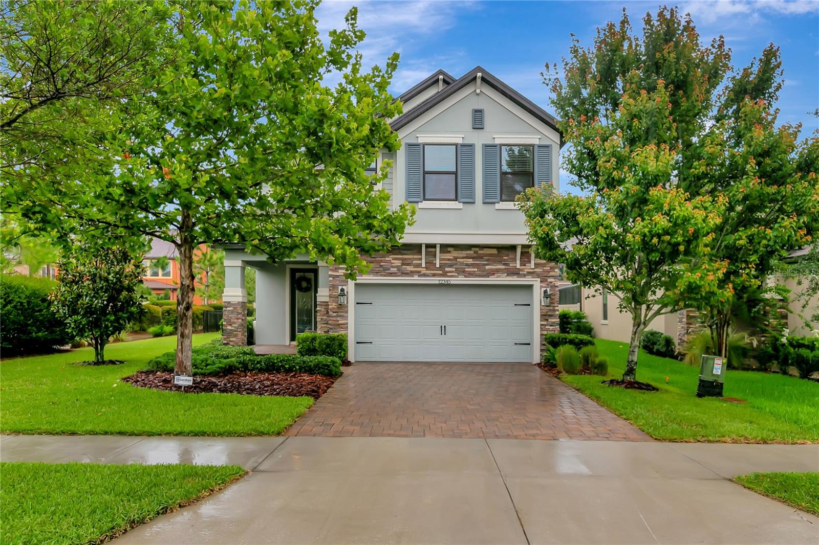 If you are looking for the perfect blend of modern finishes, character, and gracious Florida living in a highly sought-after community, look no more! This turnkey home shows like a model. Welcome to this immaculate 4 bedroom, 2.5 bath home with a flex room and a RARE large homesite and entertaining space outside in Starkey Ranch! The pavered driveway and front walk greet you as you walk in through the beautiful landscaping. You will be welcomed into the large, bright, open foyer with a two-story ceiling and hardwood staircase. Upgrades and extras throughout the home include luxurious trimwork, eye catching feature walls, wood plank tile, 5 1/4" baseboards, and recessed lighting. A large flex room features new custom built in shelving and a beverage refrigerator, and could easily become a home office, study, 2nd family room, or 5th bedroom. The light and bright great room features a complete wall of custom built-in shelving with storage cabinetry. Anchored in the center of the wall is the stone-accented fireplace and a rustic wooden mantle. The luxurious gourmet kitchen includes all of the upgrades you'd expect, including built-in double ovens, an additional microwave, gas cooktop, dishwasher, refrigerator, high-level cabinets, backsplash, and quartz counters. The oversized island offers a farmhouse sink, extra seating space, sparkling pendant lighting, and is perfect for entertaining. Enjoy meals together at the table which overlooks the customized, fully fenced backyard. Inviting pavered deck in back along with plenty of green space and lovely landscaping along the fence with palms! The pergola area is surrounded by beautiful trees. The lounge/seating area is great for entertaining or enjoying a quiet cup of coffee. Upstairs, the Owner's Bedroom is oversized and has plenty of room for your king bed, dresser, and reading chair. The owner's bath is enhanced with custom tile work, frameless glass shower, soaking tub, dual vanities, and quartz counters. Three other bedrooms share an additional full bathroom upstairs. This home has been meticulously maintained and is move-in ready! Starkey Ranch, as one of Tampa Bay's top selling master planned communities, offers everything you can imagine, including 22 miles of trails, community pools, playgrounds, parks, dog parks, and more! New $44M K-8 school, and public library just minutes away! Close to vibrant shopping and restaurants! Something for everyone! A short 25 minute drive to Fred Howard Park on the water, and world class beaches all down the coast! Only 30 minutes to Tampa Airport, and a short drive to all the amenities of the booming Tampa Bay area!