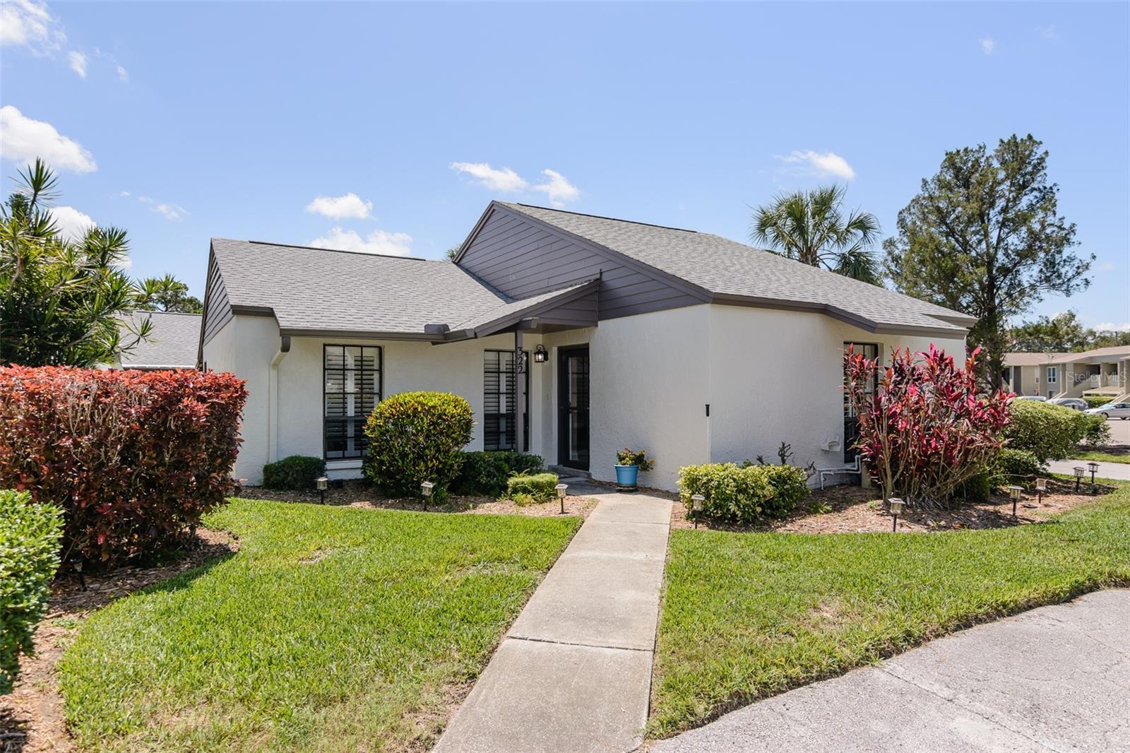 Destination for those seeking a true escape to an oceanfront community and the lure of vibrant sunsets, captivating views, dolphin watching, and waterfront lifestyle. This tastefully updated 2BR/2BA stand alone villa is just a short walk to the community waterfront boardwalk, viewing/fishing dock, heated pool and heated spa. NO DAMAGES from the 2024 hurricanes and not in a flood zone. Stress free living with exterior maintenance provided by the Condo Association. New roof in September 2022. New A/C in November 2024. Exterior painted in 2025. Wood privacy fence recently replaced by Condo Association. Two small pets welcome. Popcorn ceiling recently removed and 5.5” baseboards added. New LED can lighting. Updated kitchen with quartz countertop and newer appliances. Cathedral ceiling in great room and dining room create an open, bright, and airy ambiance. Bathrooms updated with solid wood, soft-close cabinets, granite countertops and undermount sinks. Primary bedroom has two closets, one is a walk-in closet, en-suite bath. The guest bedroom also has a walk-in closet. Hall linen closet. Laundry room with cabinets for storage and new 2025 washer & dryer. Wide plank vinyl wood-look flooring in shared living areas. Plantation shutters. Very private, spacious screened lanai for enjoying the outdoors. Sprinkler system to maintain landscaping and grass. Two assigned parking spaces. Option to purchase furniture. Monthly condo fees include water, sewer, trash, roof, landscaping maintenance, exterior maintenance, escrow reserves, pool & spa maintenance, recreational areas, and management. Make this your permanent paradise or your home away from home. Minimum 90 day rental. This home shows beautifully! Walk or ride your bike to Sunset Beach and Fred Howard Beach. Short drive to historic Tarpon Springs Sponge Dock, shopping, and fabulous restaurants. Easy drive to Clearwater Beach, known for its powdery white sand.