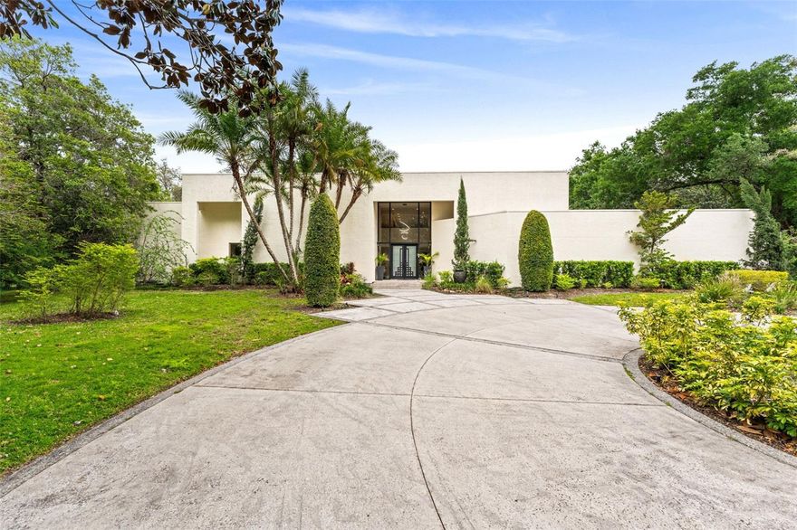 Contemporary Elegance in One of Orlando’s Most Exclusive Communities Tucked behind the gates of a prestigious enclave, this architecturally striking 8-bedroom, 6.5-bath estate spans 1.29 acres of lush, manicured grounds. Recently reimagined with a full-scale renovation, the home radiates refined, contemporary luxury from the moment you arrive. A grand modern facade with soaring glass entry welcomes you into a sun-drenched interior, where floor-to-ceiling windows frame the beautifully landscaped outdoors and flood the open-concept living space with natural light. Every detail has been meticulously curated—from the sleek open-shelf kitchen and spa-like bathrooms to the elevated finishes, luxury wallpaper accents, and designer lighting. Smart home features like electric shades, LED lighting, and all-impact glass seamlessly pair functionality with high design. Step into your own private oasis—lush tropical landscaping surrounds a resort-style pool, spa, and outdoor lounge complete with a fireplace, ideal for sunset cocktails or weekend gatherings. The thoughtfully designed layout includes a separate guest house, perfect as a private retreat, home office, or mother-in-law suite—offering both comfort and independence for extended family or guests. Located in one of Orlando’s most sought-after areas, this home offers access to top-rated schools, upscale shopping, and premier dining destinations just minutes away. Whether you’re headed to a night out or catching a flight, Orlando International Airport is within easy reach, making travel effortless. With a three-car garage, bonus room, and expansive indoor-outdoor flow, this home isn’t just a residence—it’s a lifestyle. A rare fusion of privacy, innovation, and designer flair in the heart of it all. Schedule your exclusive tour today!