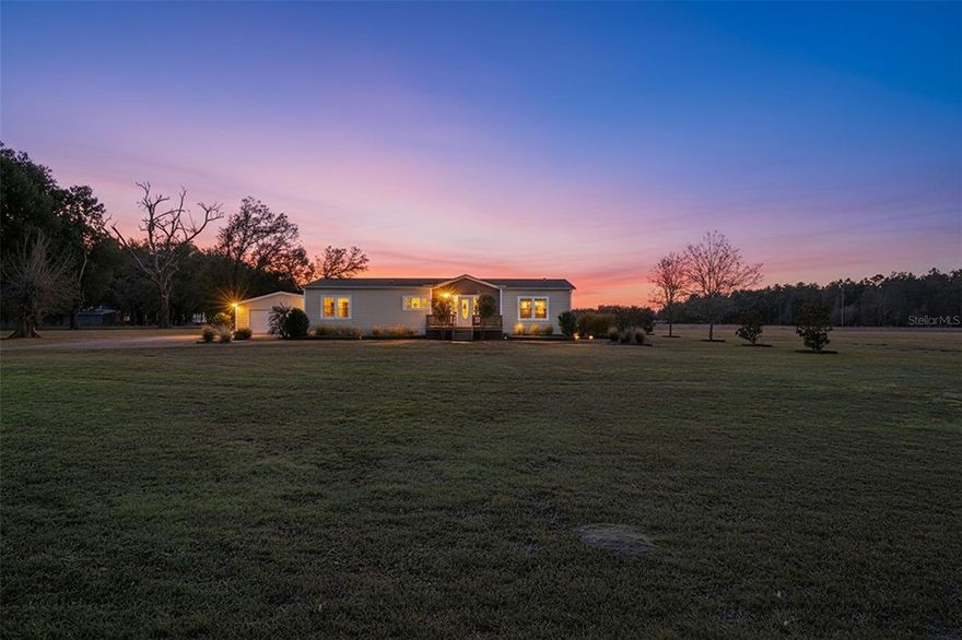 Welcome to your private slice of Florida countryside! Nestled behind a gated, fully fenced parcel of nearly 9 acres, this beautifully maintained 3-bedroom, 2-bath home offers peaceful rural living with space, style, and versatility.

A scenic drive leads you to the home, framed by mature trees and open pasture views. The exterior showcases inviting curb appeal with a charming front entry and well-kept landscaping, while the expansive acreage provides endless opportunities for animals, gardening, recreation, or simply enjoying wide-open skies. Two detached garages offer ample space for vehicles, equipment, a workshop, or hobby use.

Inside, you’ll find a bright, open-concept floor plan enhanced by tray ceilings throughout, creating a spacious and elegant feel. The heart of the home is the well-appointed kitchen, featuring a center island with pendant lighting, stainless steel appliances, abundant cabinetry, and generous counter space. The kitchen flows seamlessly into the living and dining areas, making it ideal for entertaining or everyday living.

The living area is warm and inviting with plenty of natural light and comfortable gathering space. The split-bedroom layout offers privacy, with a spacious primary suite that includes a spa-like ensuite bath complete with dual vanities, a soaking tub, separate shower, and tasteful finishes. The additional bedrooms are generously sized and offer flexibility for guests, family, or a home office.

Step outside to the covered back porch, the perfect place to relax and take in peaceful views of your land—whether enjoying morning coffee or unwinding at sunset.

This property blends modern comfort with true country freedom, offering room to roam while still being move-in ready. A rare opportunity to own nearly 9 acres with a beautiful home—schedule your showing today!