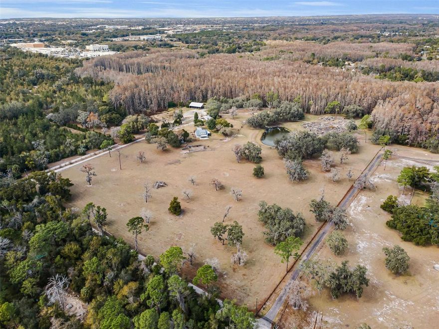 The only 30-acre homesite available in New Port Richey. Right in the middle of everything, but you feel like you are miles away. Property is level and clear. Approximately 75% uplands (MOL) with spring feed pond. Completely fenced. Site consists of very nice four-bedroom two-bath home, 1,620 square foot barn, 3,250 square foot pole barn, 5 separate carports, cattle chute, shooting range and 12 heads of cattle currently on site. Endless possibilities. Property could be subdivided or make this your dream estate. Don't miss out.