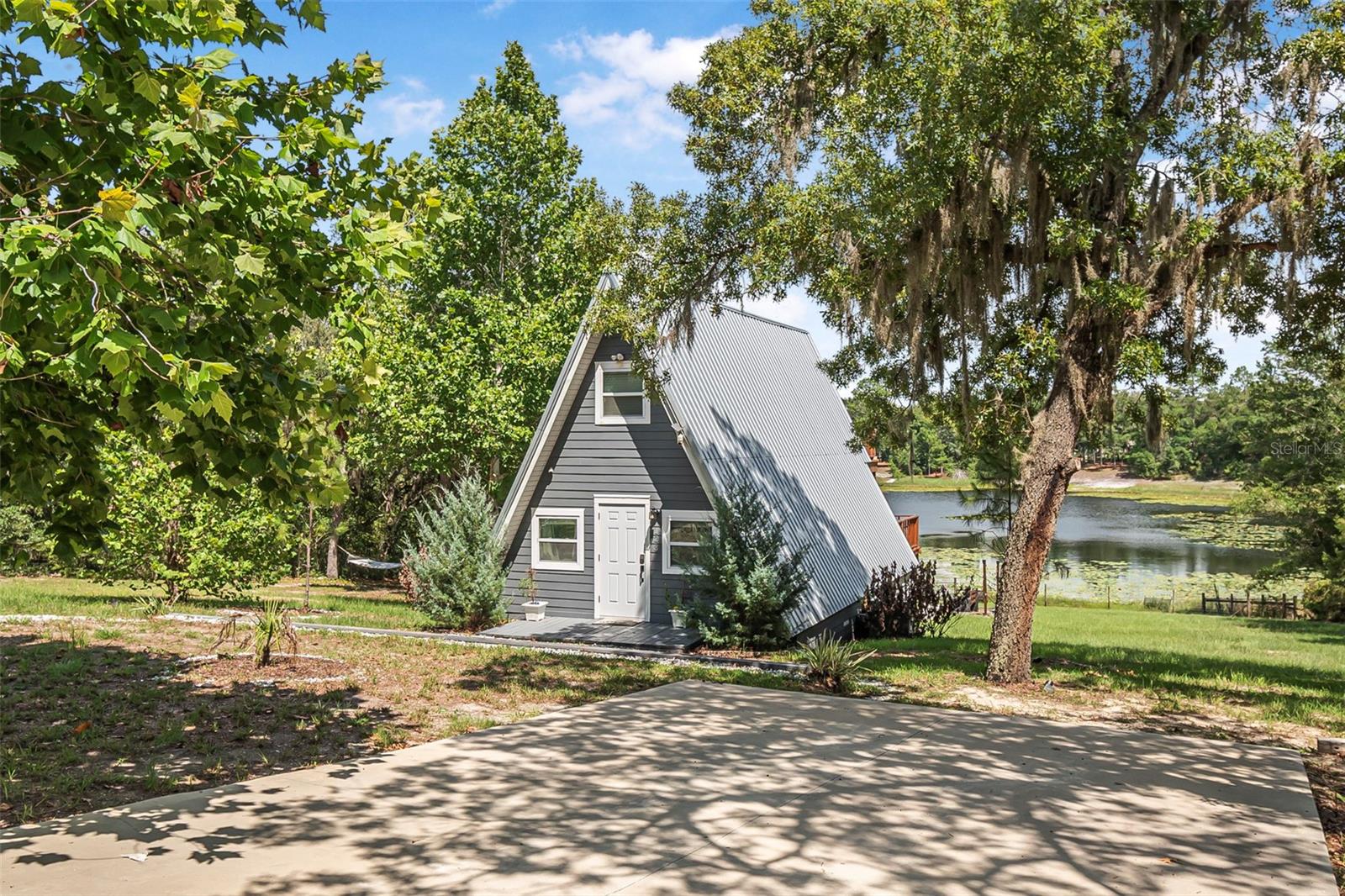 Opportunity! Are you looking for a great investment for an Airbnb or a charming escape from reality for the weekends? Escape to this stunningly remodeled A-frame lake home tucked away for perfect privacy and relaxation. You or your guests will never want to leave. This is just the property for anyone dreaming of lakeside living or looking to add a lakefront home to their portfolio. Currently operating as a thriving Airbnb, this property brings in over $60,000 annually, delivering immediate income potential from the moment you take ownership. The space has been beautifully updated. The home features 2 bedrooms, 1.5 bathrooms, and captivating water views from two private balconies—one off the primary suite upstairs and another just off the kitchen, ideal for sipping coffee while soaking in nature. There are several updates that provide peace of mind and style... a metal roof, granite countertops, stainless steel appliances, and stunning tongue-and-groove ceilings (adding even more character and charm). The upper level includes two cozy sleeping spaces and a half bath, while the main floor offers a full bath with a walk-in shower. Sitting on nearly one acre (0.96 acres), the outdoor space is just as impressive. You have direct lake access, your very own private beach, a floating dock, patio area, and a large storage shed for kayaks, paddleboards, and more. As the day winds down, relax in the hot tub with your favorite drink and watch the sun set over the water—pure magic. Can you see why the guests love this place? Whether you're searching for a top-performing short-term rental or a tranquil full-time residence, this home checks every box. Ideally located with easy access to major towns and roadways, it’s the lakefront lifestyle you've been waiting for. Don’t miss this rare opportunity—schedule your private showing today!