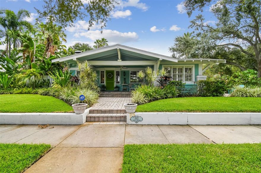 This timeless 1914 Hyde Park residence offers 2,276 square feet of character-rich living space on a rare lot and a half, perched approximately 20 feet above sea level. The property presents a unique opportunity to enjoy a  smaller-scale home in Hyde Park or take advantage of the generous lot to add a garage or guest house.
Inside, hardwood floors, ornate crown molding, custom shutters, and high coffered ceilings create a sense of grandeur throughout. The formal living room showcases built-in bookshelves and a wood-burning fireplace, while the formal dining room features beveled baseboards, a coffered ceiling, and bay windows overlooking the pool. A sunroom overlooking the side yard brings abundant natural light into the home. The kitchen is a chef’s delight, complete with dual ceiling fans, a center island with bar seating, GE Profile 5-burner natural gas cooktop with vented hood, double built-in ovens, and a cozy corner dining spot. A secondary sitting area with French doors opens to the patio, while a large laundry room adds everyday convenience. The primary suite offers a walk-in closet and a spacious sitting/dressing room that can easily be converted into an ensuite. Bedroom two highlights heart-of-pine wood floors, a custom-built bookshelf with desk, and closet units framing large double-hung windows. Outdoors, the tropical backyard is a private retreat with a resurfaced 40x15 heated pool, outdoor shower, and lush landscaping maintained by a 6-zone reclaimed water sprinkler system. A brick-paved driveway and both side and rear parking pads with space for three vehicles provide ample parking options. Additional features include underground utilities (electric, phone, fiber optic), private paver alley, Roof (2016), AC (2018).
This property is a rare find—original features, elegant touches, and room to expand—all in one. Whether you’re drawn to its historic charm or envisioning future possibilities, this home offers a truly unique opportunity