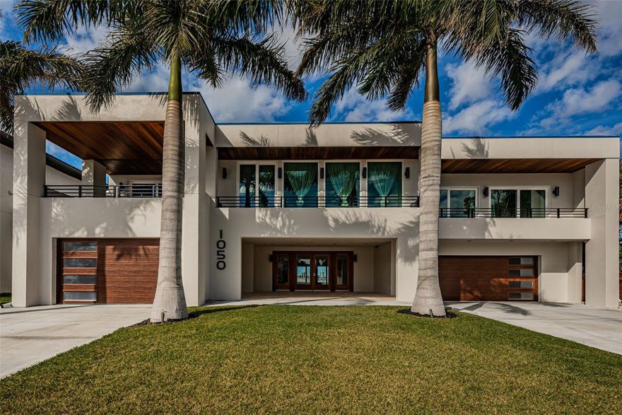 A BRILLIANTLY DESIGNED AND LUXURIOUSLY FINISHED MODERN COASTAL MASTERPIECE!  Discover the essence of contemporary waterfront living in this magnificent 10,183 total sqft estate. Complete top-to-bottom remodel in 2023! Precision contours, superbly-layered ceilings, dazzling lightwork, and rich Brazilian Walnut/Shellstone flooring give this home a sophisticated and deeply satisfying appeal.  A large 425sqft covered entry opens to a huge 1500sqft multi-purpose entertainment space (with full luxury wetbar) overlooking the pool deck. 1st level includes a lovely pool bath, laundry, bedroom. Step up to the grand living level and take in sweeping panoramic vistas of the intracoastal waterway. Gorgeous living space w/casual dining, linear fireplace, media center and built-in wine room, opens to a fabulous 58ft-wide covered balcony overlooking the waterfront.  Spectacular gourmet kitchen boasts an exquisite combination of minimalistic design and luxe amenities with posh quartz counters, Viking appliances, built-in refrigeration, 8-burner gas cooking, center island bar/work center & breakfast bar.  The inspired great room features a formal dining area and beautiful family room with access to front balcony.  Enjoy the pampering, plush feel of the alluring owner’s wing with its graceful waterfront bedroom, large covered waterfront balcony (perfect for morning coffee or nightcap), splendid walk-in closet w/elegant closet system, and attached sitting room – ideal as executive office or den.  Sumptuous owner’s bath is an indulgent retreat; resplendent tilework, stunning open-concept multi-head shower with co-located soaking tub, magnificently-finished dual vanities, cosmetics sitting area and separate, dedicated shower. 2nd bedroom suite is truly impressive with large bedroom, 225sqft private covered luxury balcony, built-in closet system and a lavish bath with hi-end materials, glass shower enclosure and jetted spa tub. Upper-level bedroom suite offers incredible sweeping water views and private 325sqft open deck with 270 degree views of St. Pete Beach.  Astonishing 490sqft covered outdoor kitchen/dining/entertainment center boasts exceptional SS cooking facilities and quartz counter dining for 10 people (area protected by electronic storm shutters). Striking Pebbletech pool/spa, additional 330sqft covered seating/lounging area, updated seawall, composite dock, 16K lb and 10K lb boat lifts. New elevator and many fine extras. This is an iconic modern waterfront marvel!  Dimensions are estimates.  Buyer to verify...Home was originally built in 1988 and extensively rebuilt in 2023..Please visit the virtual tour https://virtual-tour.aryeo.com/sites/yalloon/unbranded.