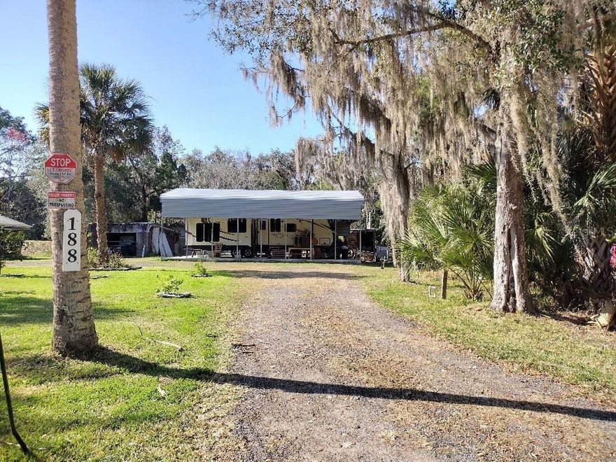 Great Weekend Retreat or Affordable Living Near Dead Lake! This 100x150’ improved lot is ideally located close to Dead Lake, featuring a county-owned boat launch and docks—perfect for freshwater fishing and outdoor recreation. The property includes a 2017 Jayco travel trailer with a private bedroom, kitchen, dining area, living space, and full bathroom, all set on a 24x40’ concrete pad and protected under a 20x40’ carport. Additional features include two garages with concrete floors, a convenient horseshoe driveway, and a variety of mature fruit trees including orange, lemon, and lime. Situated on a quiet dead-end street, this property offers privacy, functionality, and a peaceful country setting. Don’t miss this unique opportunity!  As a added bonus the seller is including a 2000 Jeep in good running condition.