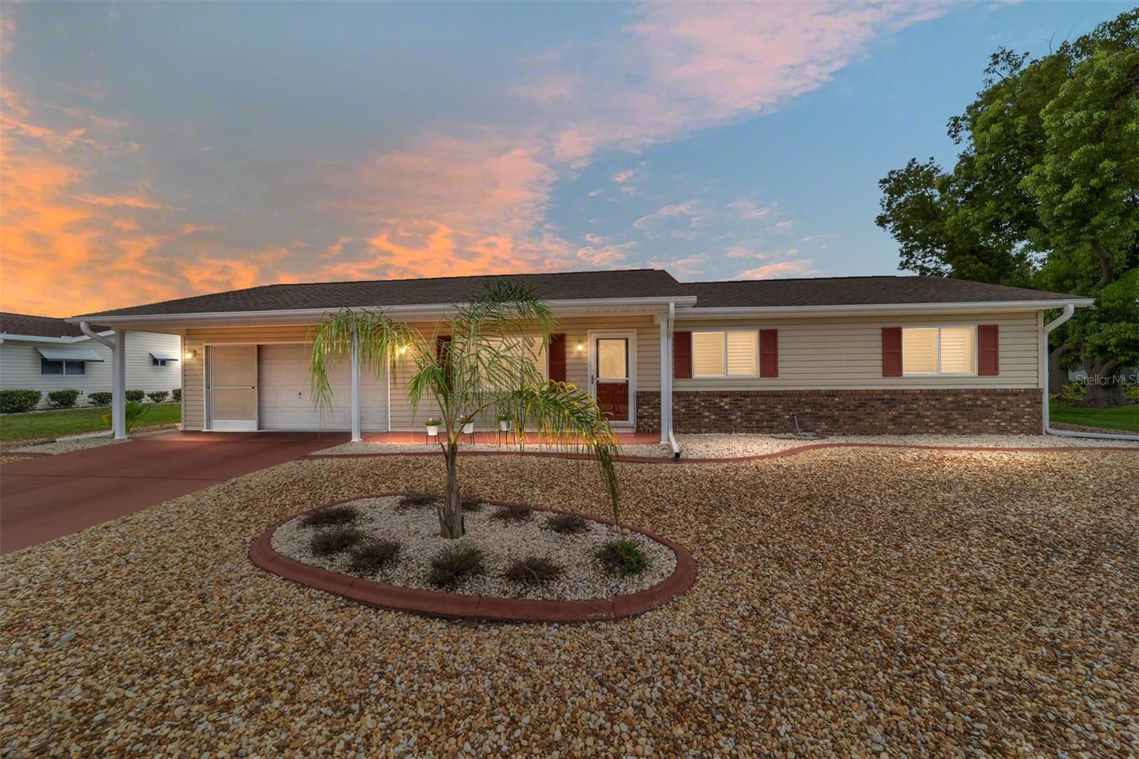 This charming 2-bedroom, 2-bath brick home, located in a gated 55+ community next to The Villages, offers 1,158 sq ft of meticulously maintained living space. It boasts modern updates including a refreshed kitchen with granite countertops, soft-closing cabinets, and a stylish backsplash, along with artistically designed bathrooms featuring soft-closing cabinets, and stylish mid-tone vinyl plank flooring throughout. The beautifully landscaped yard features designer stone accents and a fenced area for your pet, all complemented by vaulted ceilings and fresh paint. Roof (2012), HVAC (2018). New refrigerator 11/2023, new microwave 2/2024, new range 9/2024 with air fryer & convection oven, replaced all hardware & faucet in kitchen, added french doors to lanai, replaced door & 2 windows in lanai, replace Living and dining room ceiling fans with LEDs & remotes, painted front door, landscaped front yard, replaced ceiling fixture in hallway, added shelf in master closet, 6 panel doors & hardware Conveniently situated near community amenities like a center, exercise facilities, and social activities, with easy golf cart access to shopping and healthcare.