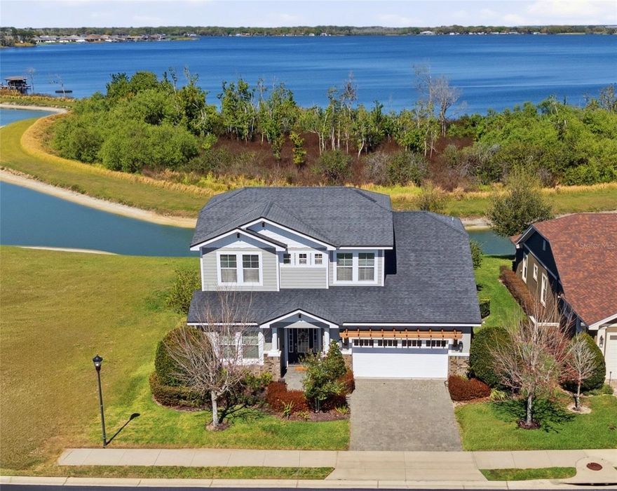 Experience refined Florida living in this custom-built 2018 Hulbert Homes pool home ideally positioned on a tranquil pond with beautiful upper-level views of Lake Van, located within the gated and highly sought-after community of Water Ridge. Offering 2,911 square feet of living area, this thoughtfully designed residence features 3 bedrooms, a private office, a spacious loft that could easily serve as a 4th bedroom, and 2.5 bathrooms, blending comfort, flexibility, and style.

Designed for both everyday living and entertaining, the open-concept first floor showcases a welcoming great room, spacious dining area, and a well-appointed kitchen. The kitchen features a large island with a breakfast bar, walk-in pantry, stainless steel appliances, and the rare convenience of two dishwashers. Gorgeous wood flooring flows throughout the living spaces, complemented by elegant crown molding that adds a refined touch throughout the main living areas.

The primary suite is privately located on the first floor and enjoys peaceful pool views, along with a generous walk-in closet with linen storage and a spa-like en-suite bath featuring granite countertops, dual sinks, a freestanding soaking tub, and a large walk-in shower. Also on the main level are a private office with French doors, a convenient guest half bath, mudroom off the garage, inside laundry room with extensive cabinetry and granite folding counter, and access to the 2-car garage with epoxy flooring.

Upstairs, the expansive loft offers flexibility as a second living area, playroom, or potential fourth bedroom, while picture windows capture stunning views of Lake Van. Two additional generously sized bedrooms share a well-appointed bathroom with granite countertops, dual sinks, and a tub/shower combination. The home also provides excellent storage, including multiple closets, an under-stair storage space, a walk-in storage closet, and additional linen storage upstairs.

Outdoor living is equally impressive with a screen-enclosed saltwater swimming pool built in 2021, surrounded by pavers and complemented by a covered lanai perfect for year-round enjoyment. Whether hosting friends under the covered patio with the wall-mounted TV or relaxing poolside in the Florida sunshine, this backyard retreat was designed for both entertaining and relaxation.

Additional features include ceiling fans and window blinds throughout, an irrigation system with timer, mature landscaping, and more.
Residents of Water Ridge enjoy an exceptional lifestyle with resort-style amenities, including a clubhouse, state-of-the-art fitness center, sauna, three community pools (including a lap pool), tennis, basketball and pickleball courts, three boat docks, community boat ramps, and boat/trailer storage.

Ideally located between Tampa and Orlando, this beautiful home offers the perfect blend of luxury and convenience in one of Central Florida’s most desirable gated communities. Schedule your private showing today and experience Water Ridge living at its finest.