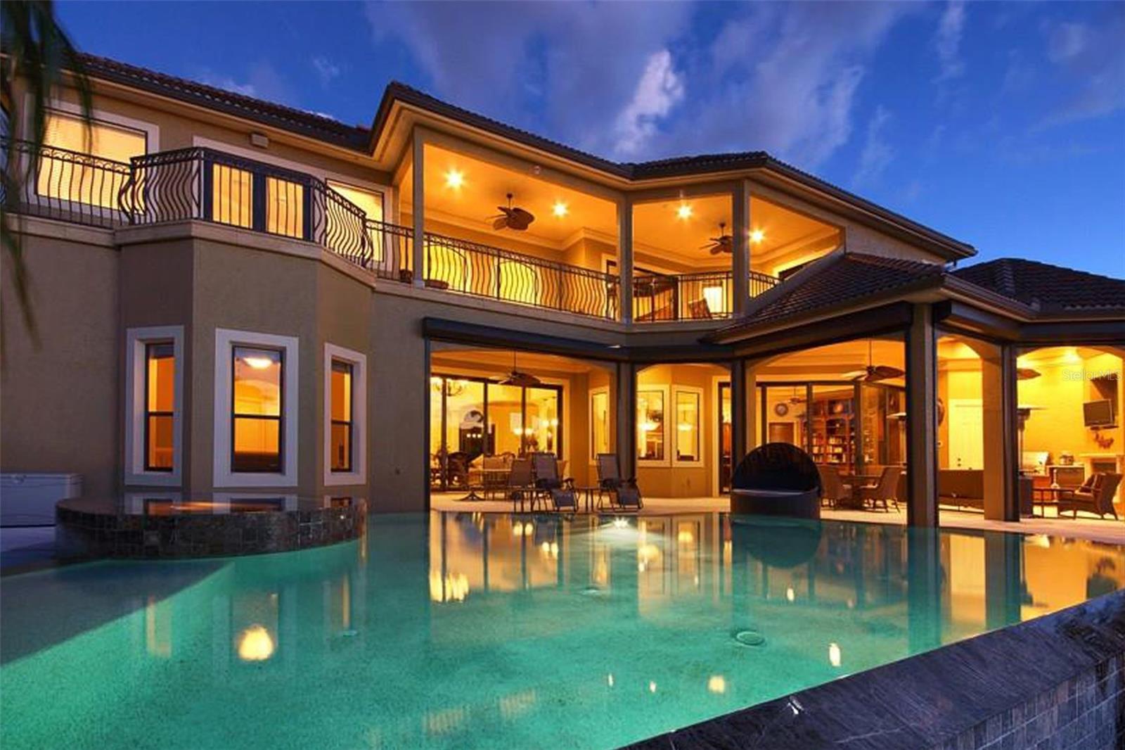 A Rare Waterfront Masterpiece: Ultimate Luxury, Prime Location, Limitless Potential! Welcome to your dream escape in Southwest Florida—where timeless elegance meets unmatched boating access. Whether you're envisioning a private estate, a luxury vacation rental, or a corporate retreat, this impeccably crafted home offers the perfect balance of comfort, sophistication, and opportunity. Nestled on an oversized corner lot, this stunning Koogler-built residence is just one turn from the Caloosahatchee River—no bridges, no locks, and pure open-water convenience. Designed for those who crave the best in waterfront living, this property is both a serene sanctuary and an entertainer’s dream. From the moment you arrive, grand double glass doors with wrought iron detail open to a stately foyer, setting the tone for the home’s refined style. The formal living room dazzles with a dramatic chandelier, stone-accented electric fireplace, and seamless indoor-outdoor flow through expansive sliders to the lanai. Nearby, the formal dining room is an ideal space for elevated entertaining, complete with a wet bar, U-Line appliances, and a Marvel beer tap. The primary suite is a private retreat, showcasing double-door entry, tray ceiling, custom his-and-hers closets, lanai access, and a spa-inspired bath. Indulge in a jetted soaking tub, granite dual vanities, a spacious walk-in shower with dual shower heads, and precision temperature controls. The heart of the home—the chef’s kitchen—is outfitted with premium KitchenAid appliances, a Viking 6-burner gas stove with griddle, dual dishwashers, granite countertops, and a walk-in pantry. A cozy breakfast nook opens to the inviting family room with built-in entertainment and lanai access, creating effortless flow for everyday living or large gatherings. Step outside to a resort-style lanai with a tongue-and-groove ceiling, half bath, built-in GE Monogram grill and refrigerator, and a cozy gas fireplace. The electric-heated saltwater pool and spa feature a sun deck and gated access to your private dock—crafted from composite decking and equipped with water, electricity, and dual boat lifts (10,000 lb and 20,000 lb). 200 feet wide canal, 66 feet dock with 21 feet width. Upstairs, a generous entertainment loft offers a billiards area, full bar with granite counters, and balcony access. Guests will feel pampered in spacious en-suite bedrooms with custom walk-in closets and private balcony access. A well-appointed laundry room with GE Profile appliances and an additional half bath complete the second floor. This versatile luxury residence is as functional as it is exquisite—ideal for homeowners, investors, or business professionals seeking an elite retreat in paradise. Don’t miss this extraordinary opportunity. Schedule your private tour today and experience the pinnacle of waterfront luxury living.