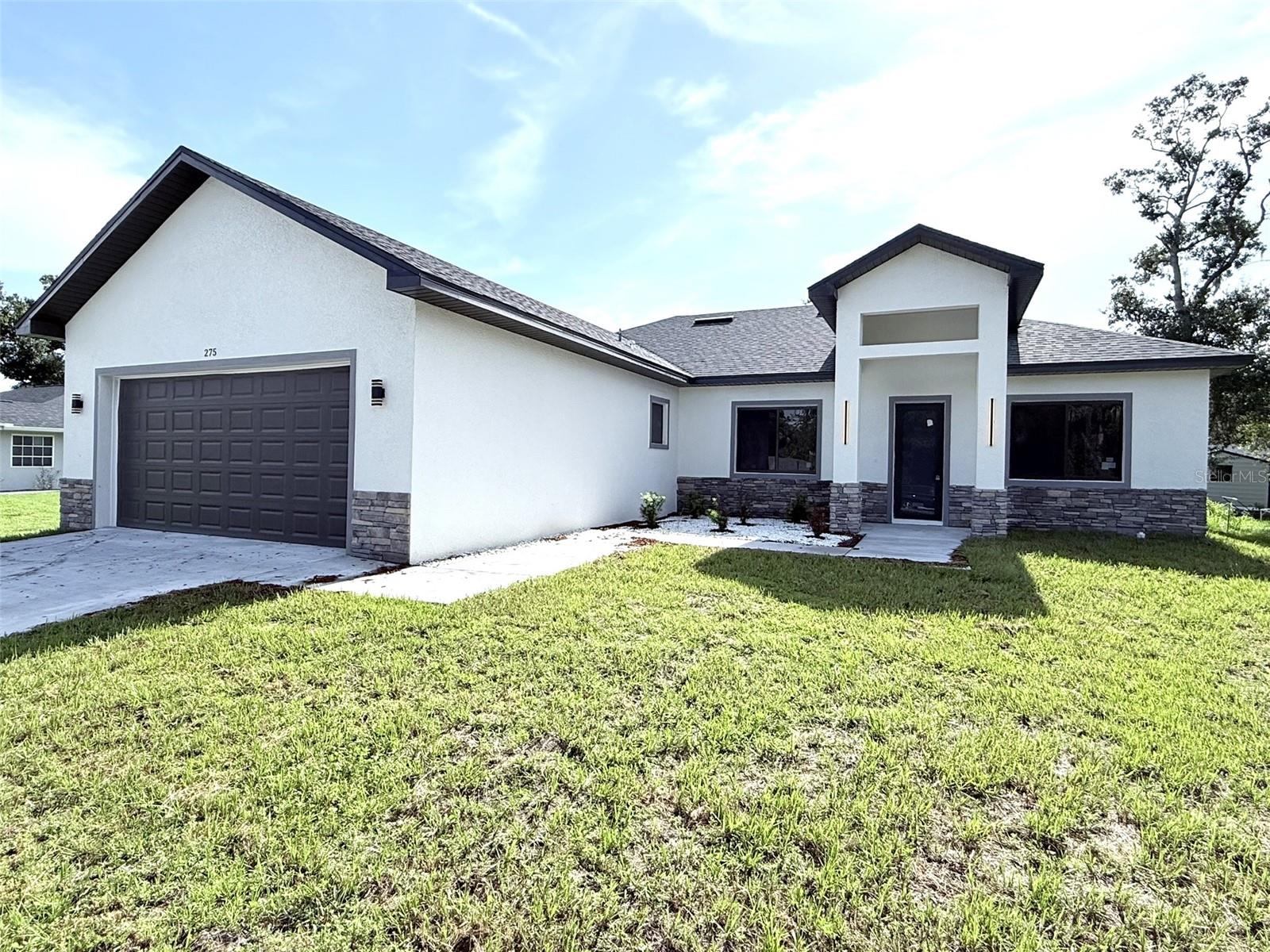 Introducing a newly constructed four-bedroom, three-bath residence in the heart of Port Charlotte. Spanning 2,153 square feet of living space and totaling 3,099 square feet, this home combines modern architecture with function and refined detail. The open-concept floor plan seamlessly integrates the living and dining areas, creating an inviting space for daily living and entertaining. A gourmet kitchen anchors the interior, featuring state-of-the-art stainless steel appliances and luxury finishes. High-quality vinyl flooring runs throughout, complementing soaring 10-, 12- and 13-foot ceilings that enhance the home's scale and light. The primary suite is a private retreat with a spa-style bath including a soaking tub, walk-in shower, double vanity and an oversized walk-in closet. Additional features include a laundry room with sink and pre-designed layout for future home enhancements. Thoughtful exterior design includes modern elevation details, sliding windows, a metal and glass front door, soffit lighting in the rear area and strategically placed gutters. The home sits on a site ready for a pool and has summer kitchen connections ready and water softener installed. Built in 2025 with an emphasis on craftsmanship and contemporary design, this property presents a rare opportunity to own a new-construction home in an established area of Port Charlotte.