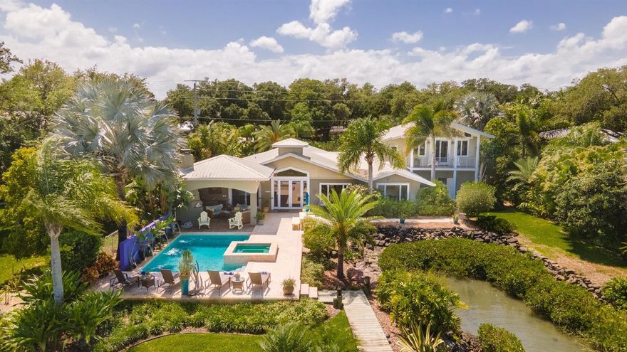 Custom Intracoastal 4 bedroom, 4.5 bath residence with fabulous pool, lanai and dock.  Situated on almost half an acre, this property offers an amazing amount of privacy with stunning views.  Ideal floorplan features master suites both upstairs and down.  Another suite has sitting room and separate entrance and makes ideal in-law quarters.  The kitchen is built for entertaining with large bar and large island providing lots of room for family and friends to gather.  Stainless appliances, beautiful Cherry cabinetry, gleaming granite and tons of cabinet and counter space plus a perfectly situated butler’s pantry and laundry make multi-taking and organizing a breeze. The cozy family room with natural gas fireplace overlooks the lanai. The master suite has cathedral beamed ceilings, private riverfront balcony and marble bathroom with whirlpool tub.  The downstairs suite overlooks a peaceful tidal cove. Travertine floors and Ipé decking.  Jeldwynn impact windows, sliders, french doors and beautiful custom woodwork throughout.  The covered lanai with wood-burning fireplace and summer kitchen overlook the resort-like gas heated salt pool and spa with private pool bath and changing room.  Natural gas for tankless water heater, 16000kw generator, stove and summer kitchen.  Covered dock with 8000 lb lift.  This property is sold furnished subject to list of exclusions attached.   Note: A small portion of the home was existing in 1986 and was completely renovated in 2007 along with new additions & a second story. ;Water: City