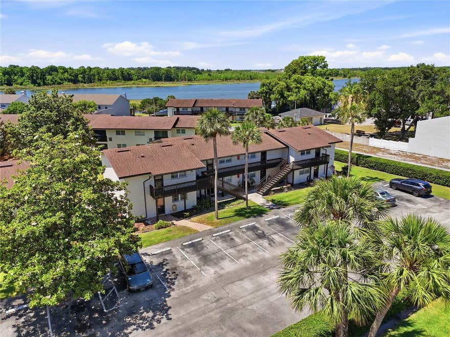Ground-floor, furnished condo in Sandy Cove, a lakefront community on the beautiful Winter Haven Chain of Lakes. This furnished 2-bedroom, 1-bath unit offers low-maintenance living that’s ideal for full-time residents, seasonal owners, retirees, or anyone seeking a convenient Florida lifestyle. The layout offers comfortable living with a spacious great room featuring laminate flooring, a ceiling fan, and sliding doors leading to the enclosed Florida room. The adjacent dining space is cozy and ideal for entertaining or quiet nights in. The kitchen is complete with quartz countertops, included appliances, and a stackable washer and dryer. The unit also features double-pane windows for improved energy efficiency, comfort, and noise reduction. The primary bedroom is generously sized and features a ceiling fan, walk-in closet, and direct access to the bathroom. The guest bedroom is also comfortably sized with a built-in closet, ceiling fan, and en-suite-style bathroom access. The bathroom has been updated with an upgraded vanity, solid-surface countertop, and walk-in shower. Enjoy outdoor living from the enclosed Florida room with screens and vinyl windows, perfect for relaxing or entertaining year-round. This ground-floor unit is ideally positioned just steps from the community clubhouse, grill area, and heated pool maintained at approximately 85 degrees for year-round enjoyment. Sandy Cove also offers a community dock on Lake Lulu, one of twenty+ lakes on the Winter Haven Chain, providing a peaceful setting to unwind, enjoy waterfront views, and take in beautiful Florida sunsets. Residents enjoy the relaxed lifestyle that makes Winter Haven so desirable, including boating, fishing, lakeside dining, golf courses, walking paths, and year-round community events. Conveniently located near everyday essentials and recreation, the condo is just minutes from Publix Super Markets, CVS Pharmacy, restaurants, banks, medical offices, and Walmart shopping. Nearby public boat access on Lake Summit makes it easy to enjoy the Chain of Lakes lifestyle, while several local golf courses are only a short drive away. The location also provides convenient access to both Orlando and ,making this an excellent choice for easy, low-maintenance Central Florida living.
