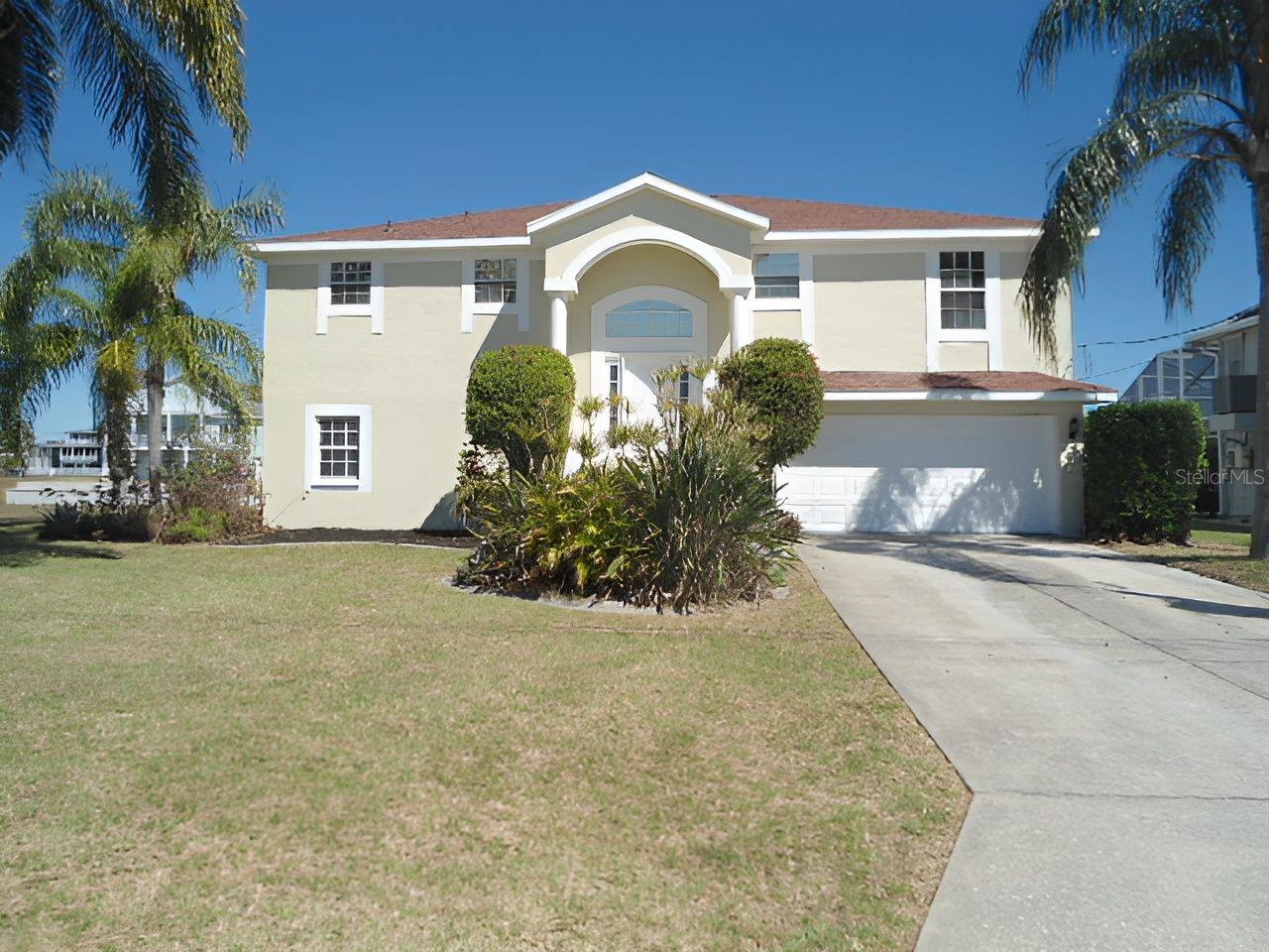 Waterfront home located in deed restricted Hernando Beach South with indirect access to the Gulf of Mexico. This move in ready home has a new roof in 2025, freshly painted interior and exterior, new carpeting and flooring, and both baths have been updated. This home features an eat-in kitchen with granite countertops, breakfast bar, panty and French doors that lead out to the lanai; the spacious great room has a vaulted ceiling and sliders that open up to the lanai, the updated primary bedroom suite bath has dual sinks and a walk-in shower, and bedrooms 2 & 3 are generously sized. The lower level has almost 1600 square feet of garage and storage space. The back yard has vinyl fencing and there's a floating dock to fish off of and to dock your boat.