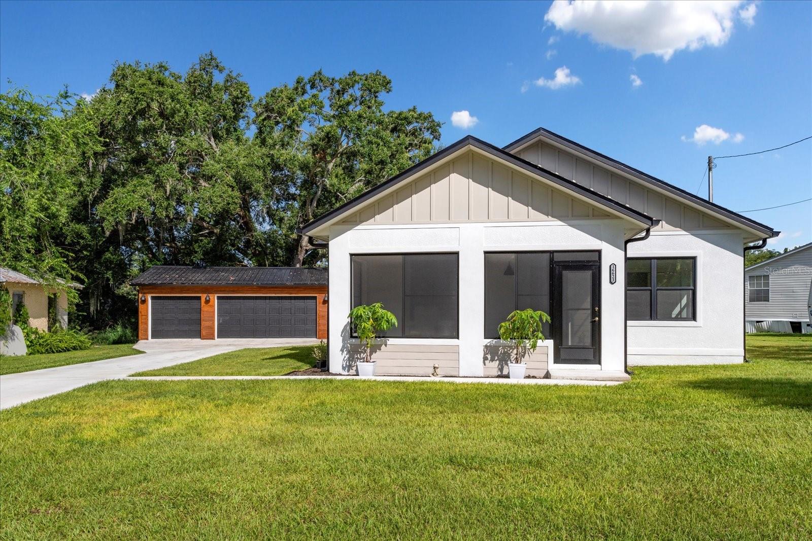 One or more photo(s) has been virtually staged. New 3/2 Custom Built Home with Detached 3+ Oversized Garage/Workshop, Built in 2024. Location, location, Close to Lake Minneola-Chain of Lakes in an Unincorporated NO HOA, small Neighborhood, close to US Hwy 27 & Hwy 50. Seller was planning to build another home on the lot next door, though has made other plans. Home is approx. 1,554 sq. ft, plus 3+ Garage/ with oversized Workshop area - approx. 840 sq ft., with room for Office, Gym or Man Cave!! Additional sq ft. with screened enclosed-covered Front Porch & covered open roof large Lanai in the back of home. Home is Move-in Ready, with a deep driveway for a Car Collection, or Home Business. There is plenty of room to bring your Boat, RV, Motorcycles, Mountain Bikes and Toys with you. Must see, Builder spared no expense with upgraded Products, Appliances & finishes; vaulted ceilings, wood accent ceiling beams throughout open floor plan, custom kitchen island, farmhouse kitchen sink, aaccent walls in bathrooms, split bedroom floor plan and more.