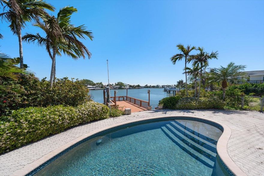 One or more photo(s) has been virtually staged. Perfectly situated along the peaceful waterfront of Indian Rocks Beach, this Mediterranean-inspired residence embodies relaxed coastal luxury. A paver circular driveway and grand double entry doors create impressive curb appeal and a welcoming first impression. Inside, the light-filled interior offers a well-designed layout featuring a dedicated office and a cozy formal living room centered around a charming brick fireplace. The heart of the home is a beautifully designed kitchen with granite countertops, a breakfast bar, and a center island, all opening to a spacious family room with soaring vaulted ceilings, custom built-ins, and dramatic floor-to-ceiling windows showcasing stunning water views. French doors lead to a true outdoor retreat where a sparkling pool and spa overlook the tranquil waterfront—perfect for entertaining, relaxing, or enjoying dolphins and manatees passing by. Embrace the best of Florida living with mornings on the water and afternoons by the pool. The split bedroom layout ensures privacy, highlighted by a spacious primary suite filled with natural light, a walk-in closet, and an ensuite bath with double vanity, generous storage, and a walk-in shower. Additional bedrooms are well-sized with ample closet space and share a nicely appointed hall bath with a tub/shower combination. Features such as crown molding and central vacuum add comfort and convenience throughout. Ideally located near local shops, dining, and the area’s renowned white sand beaches, with easy access to the mainland via the nearby Belleair Causeway, this exceptional waterfront home offers an unparalleled coastal lifestyle.