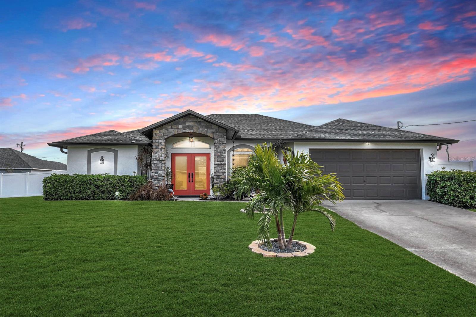POOL HOME, IMPACT PROTECTION, LOADED w/STYLISH UPGRADES! Discover the ultimate Florida retreat, perfectly situated on a spacious triple lot in the heart of SWFL. Home features 3 BR, 2 BA and 2 car GAR with just under 2200 sqft of living space. Step inside through the stacked stone accents and double front doors, where you’ll find high ceilings with decorative wood tongue and groove tray ceiling designs and features throughout, creating a warm and sophisticated atmosphere. Wood plank tile flooring spans the home, complemented by crown molding and decorative niches with stacked stone inlays. The heart of the home, the kitchen, was completely remodeled in 2024. It showcases quartz countertops with a matching backsplash, a large sink, and sleek stainless steel appliances. The open-concept design includes both a family room and living room, each with direct access to the pool area. The spacious primary suite is a serene retreat, offering two walk-in closets, private access to the pool, and a spa-like en-suite bathroom. The bathroom features a jacuzzi tub, a walk-in shower, dual sinks with quartz countertops, and extra storage space. The outdoor living space is a true showstopper. The outdoor oasis features a heated salt water pool and spa, installed in 2023, complete with a sunshelf adorned with charming blue crab mosaics and a relaxing water bubbler feature. Surrounding the property is a newly installed 6-foot privacy fence (2023), providing seclusion and tranquility. IMPORTANT UPGRADES: Generator ready with buried 500-gallon propane tank and electrical transfer switch in place, NEW 4-ton A/C unit with updated ductwork (2024), pre-wired for electric shutters and an Entek whole-home water filtration system. The lanai features pavers and a custom shiplap wood ceiling. A separate pavered grilling deck completes the backyard, providing a perfect setting for gatherings or quiet evenings under the stars. With a new shingle roof and impact windows and doors (2024), as well as fresh exterior and interior paint (2025), this home is as functional as it is beautiful and is move in ready. Located in a sought-after area, this gem offers a unique opportunity to enjoy the Florida lifestyle at its finest, just minutes away from all the conveniences and coastal charm Cape Coral has to offer: outdoor activities, good food, temperate weather year round, boating, kayaking, jet skiing, world class fishing & white sandy beaches at your fingertips! Located in Flood Zone X!