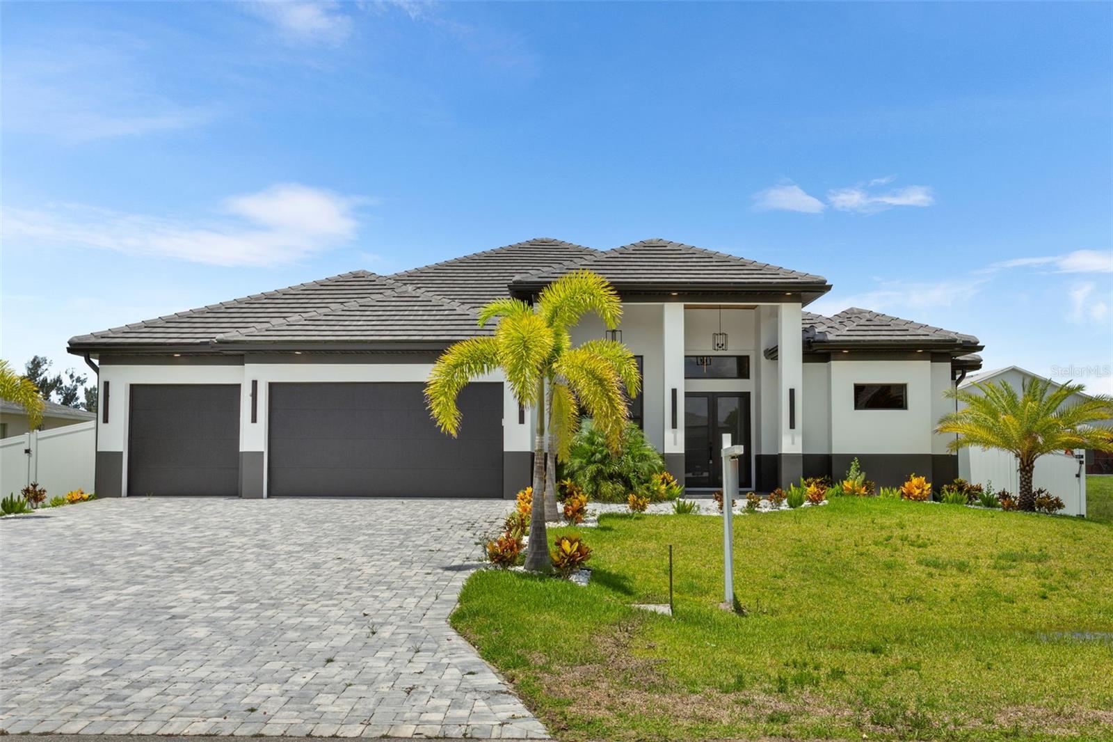 Experience REFINED LIVING in this MODERN LUXURY RESIDENCE in Cape Coral, SWFL PARADISE! STRIKING EXTERIOR PALETTE of CHARCOAL GRAY, BLACK, and CRISP WHITE, this NEW CONSTRUCTION HOME blends BOLD CURB APPEAL with ELEGANT DESIGN, inviting you to own a piece of paradise! It features 2,420 sq ft of living area with BRIGHT and OPEN LAYOUT designed for both EVERYDAY COMFORT and UPSCALE ENTERTAINING. The ENTIRE HOME features SPANISH PORCELAIN TILE, enhancing its CLEAN LINES and TIMELESS STYLE. Inside, you’ll find 3 SPACIOUS BEDROOMS plus A VERSATILE DEN (easily used as a 4th bedroom if needed) and 3.5 beautifully appointed BATHROOMS. Enter through the COVERED FRONT PORCH and GRAND DOUBLE DOORS into a SOARING 16-FT FOYER, where a NEUTRAL PALETTE OF WHITE, LIGHT GRAY, and CASHMERE WELCOMES YOU HOME! Exposed WOOD BEAMS and COVE CEILING add ARCHITECTURAL INTEREST and WARMTH, creating an ATMOSPHERE IDEAL FOR RELAXATION or HOSTING! CHEF-INSPIRED KITCHEN equipped with STAINLESS STEEL APPLIANCES, CUSTOM CABINETRY, QUARTZ COUNTERTOPS, and A LARGE SINK complete with a SLEEK MATTE BLACK FAUCET with pull-down spring spout. The EXPENSIVE ISLAND offers FLEXIBLE SEATING for CASUAL DINING or FORMAL GATHERINGS, and a FULL QUARTZ BACKSPLASH adds MODERN SOPHISTICATION! A DEDICATED WINE CLOSET with 55-bottle DISPLAY RACK adds a LUXURIOUS TOUCH to your ENTERTAINING SPACE! The PRIMARY SUITE is a PRIVATE RETREAT, complete with DUAL WALK-IN CLOSETS and a SPA-STYLE BATH featuring a FREESTANDING SOAKING TUB, RAINFALL WALKTRHOUGH TILE SHOWER, CUSTOM VANITIES and QUARTZ SURFACES for a truly REJUVENATING EXPERIENCE. The SPLIT BEDROOM LAYOUT ensures PRIVACY with a LARGE GUEST SUITE, separate HALL BATHROOM, and ADDITIONAL GUEST BEDROOM thoughtfully arranged to GIVE EVERYONE THEIR OWN SPACE! Step outside to your PRIVATE POOL, perfect for SUNNY SOUTHWEST FLORIDA DAYS and NIGHTS! The OUTDOOR KITCHEN is READY for ENTERTAINING with a BUILT-IN BBQ GRILL, MINI FRIDGE, COMMERCIAL GRADE SINK, and plenty of counter and cabinet space for all your CULINARY NEEDS. A 3-CAR GARAGE offers ABUNDANT ROOM for vehicles, storage, or weekend toys. This home is not only a SANCTUARY OF COMFORT and STYLE but also ideally located in CAPE CORAL - famous for its vibrant lifestyle, scenic parks, boating canals, golf courses, and easy access to nearby Gulf Coast beaches and family-friendly amenities. WELCOME TO YOUR COASTAL DREAM HOME, WHERE DETAILS WERE CURATED FOR CONTEMPORARY ELEGANCE AND EVERYDAY EASE! Located near the upcoming SEVEN ISLANDS WATERFRONT COMMUNITY in NW Cape Coral, featuring future marinas, parks, dining, and resort-style amenities, this property offers INCREDIBLE POTENTIAL!!! As development continues, home values are expected to rise, making this A SMART INVESTMENT OPPORTUNITY! Don’t miss your chance to BUILD EQUITY EARLY!