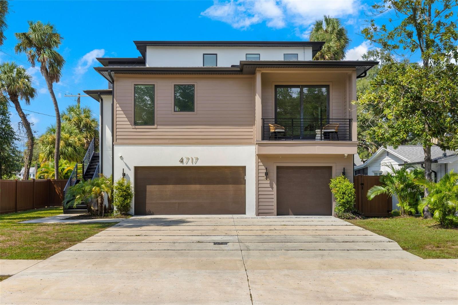 Exceptional South Tampa Modern Residence in Sunset Park! This striking 2-story home offers four bedrooms, four and a half bathrooms, and an impressive 4,190 square feet of thoughtfully designed living space. Elevated and sitting high and dry, it delivers peace of mind along with modern luxury in one of Tampa Bay’s most desirable neighborhoods—nestled within the highly sought-after Plant High School District, consistently rated among the best in the area. Upon entering the main level, you’re welcomed by a spacious open floor plan. The family room features a custom accent wall and seamlessly flows into the chef’s kitchen, which showcases double waterfall islands, sleek black cabinetry, professional ZLINE appliances, and a wine bar with refrigeration. Brand new engineered hardwood flooring throughout the downstairs adds warmth and elegance to the modern design, while electric window shades installed throughout allow for privacy and comfort at the touch of a button. The main-level Primary Suite is a private retreat with wide plank oak flooring, a private terrace, a large custom closet with built-ins, and a spa-inspired bath featuring a soaking tub, an impressive 10-foot frameless glass shower, slate flooring, and floor-to-ceiling tile. A dining room, home office, and powder bath complete the first floor. Upstairs, you’ll find three additional ensuite bedrooms, each with large walk-in closets, plus a full laundry room for convenience. Outdoor living is just as impressive, with a covered terrace overlooking the private pool and waterfall spa, patio, and landscaped side yard—all fully fenced for privacy.Additional highlights include a striking glass stairway and interior railing system, impact-resistant windows and doors, and a 3,000+ sq ft garage that offers parking for 10+ cars, storage, and bonus flex space. Located in Sunset Park and zoned for the Plant District, this home offers unmatched convenience to Tampa International and St. Pete/Clearwater Airports, International Plaza, Midtown Tampa, Water Street, Hyde Park Village, award-winning beaches, and top-rated schools.