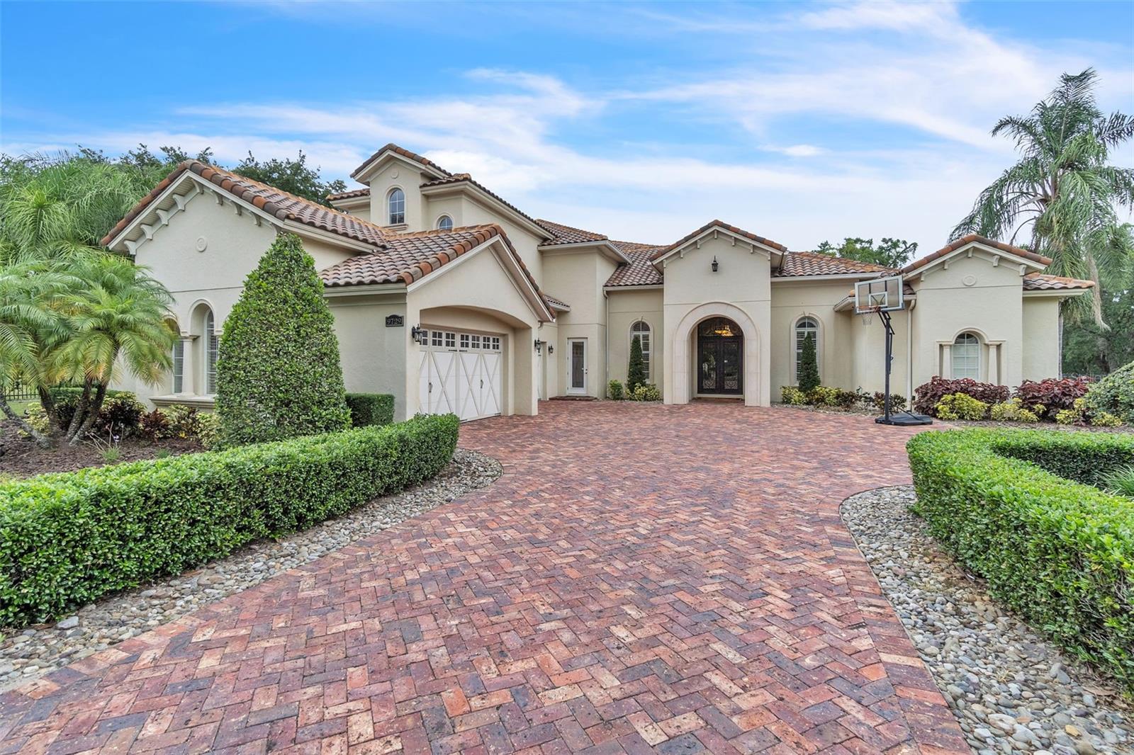 Welcome to this exquisite custom-built estate located in the Braemar community of Gotha, Florida. Situated on a spacious 0.84-acre lot, this luxurious 5-bedroom, 7-bathroom home spans an impressive 6,058 square feet of living space. Meticulously designed with both elegance and functionality in mind, this property offers unparalleled comfort and style. The home features a master suite with a sitting area and French doors that open to the backyard pool, offering a tranquil retreat. The split floor plan provides privacy and convenience, with additional bedrooms, a home office, and plenty of room for relaxation. A chef’s dream, the kitchen is equipped with top-of-the-line appliances, including a gas range, custom cabinetry, and a large center island, perfect for culinary enthusiasts and entertainers alike. Enjoy a fully-equipped home theater with a surround sound system, as well as multiple game rooms located on both the main and upper levels. The ultimate in-home entertainment experience awaits. Step outside to your own private paradise featuring a luxurious pool and spa with specialty lighting and jets, an outdoor kitchen for al fresco dining, a fire pit, and a putting green, all designed for both relaxing and entertaining. Equipped with an advanced security system, this home also features an ON-Q and ELAN music and communication system for seamless connectivity throughout the estate. With ample parking and storage, the four-car garage ensures plenty of space for vehicles and additional items. This stunning property offers the perfect blend of modern luxury, comfort, and functionality. Whether you’re hosting grand events or seeking quiet relaxation, 9729 Lake Hugh Drive is the ideal place to call home. Don’t miss the opportunity to make this dream estate yours.