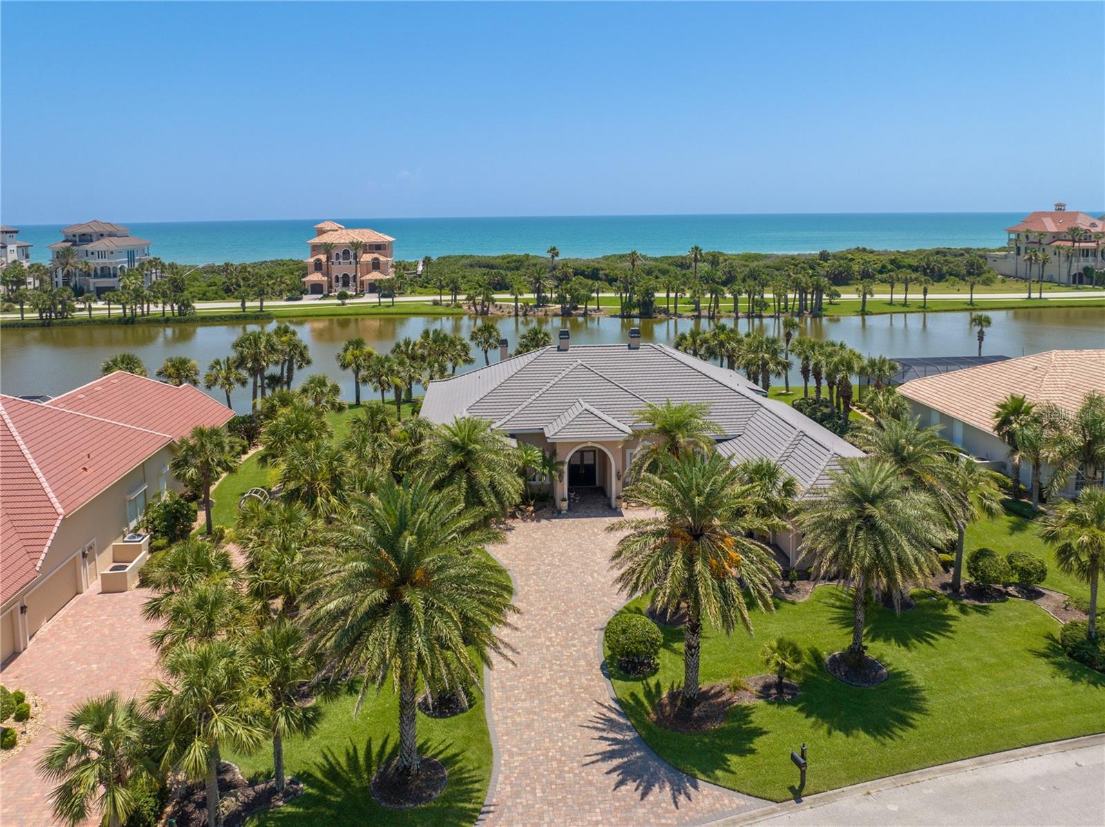 Magnificent, Estate Home located in the Gated, Oceanfront Community of Hammock Dunes. Exquisitely built by renowned Custom Home Builder, "Machin Design Builders" in 2007. Ideal floor plan with 4534 SF on ONE LEVEL. One of the largest lots (23,821 SF) on San Gabriel. The land projects East in to Lake San Gabriel which provides captivating 180 degree views of the Lake & wildlife. The home has been expertly sited with views looking up and across Lake San Gabriel and water views from all of the primary rooms. The Owners spared no expense in building this "Luxe property" w/12' & 14' ceilings, oversized windows with transoms, custom cabinetry, exotic granites, oversized custom millwork with 5" baseboard moldings, 4" trim around doors and windows, 3 piece crown moldings, and solid wood doors are just a few features. See Special Features list for more details. Perfect for entertaining with a centrally located Wet Bar with sink, beverage refrigerator & wine cooler. 2 Sets of French Doors open to the inviting Lanai overlooking the Pool, Spa & Lake San Gabriel. The Lanai wood burning fireplace adds just the right atmosphere for a cool Winter evening. The Pool is set on an angle to enjoy the Lake views. Imagine spending time year round on this stunning Lanai. Pool Heater (250k BTU) replaced in June 2023. Chef's Kitchen features an abundance of custom cabinetry, exotic granite counter tops, Large Center Island w/vegetable sink, 6 Burner "G.E. Monogram" cook top, 48" side by side refrigerator (replaced in 2016), "Bosch" dishwasher, "G.E. Monogram" double wall oven & microwave. All appliances have transferable warranty through 2026. Dining Room has gorgeous Butler's Pantry for additional storage & convenience. The Family Room has 2 walls of disappearing sliding glass doors which open to the Lanai & the stunning views of the Lake. 4 En-Suite Bedrooms. 4th Bedroom is used as an office with elegant cherry built in cabinetry and desk. Imagine working at your desk as you watch the Pelicans fly over the natural dunes. The Master Suite is wonderful with large windows overlooking the Lake, 2 large walk in closets with custom built-ins, Master Bath with walk in shower & garden window, soaking tub, & separate vanities. Home comes complete with security system & cameras, and sound system. The Bonus Room can be used as an Exercise Room, Second Office, Hobby Room, Play Room, Prep Kitchen or Air Conditioned Storage. The oversized 3 car garage has shelving & cabinetry, sink & attic access. The home has impact glass windows & doors & lightning protection. 2 HVAC systems replaced in 2015, electric Hybrid hot water heater replaced 2020. See Document link for Floor Plan, Special Features List & Survey. Membership to the Private Hammock Dunes Club is available but not required. The Private, Oceanfront Hammock Dunes Club is ranked as an "Emerald Club of The World". Enjoy Fantastic food in one of the 3 Oceanfront dining rooms or at the additional Clubhouse at the Creek Course. Hammock Dunes has 2 18 Hole golf courses by Rees Jones and Tom Fazio. In addition, Hammock Dunes Club offers an Oceanfront Heated Pool, 5,000 SF "state of the art" Fitness Center, Tennis, Pickleball, Oceanfront Croquet, in addition to an array of Fantastic Social Events. Conveniently located on the Atlantic, Central Florida Coast just 1 hour to Jacksonville or Orlando and 30 minutes to St. Augustine or Daytona Beach. Locals call it "Paradise".