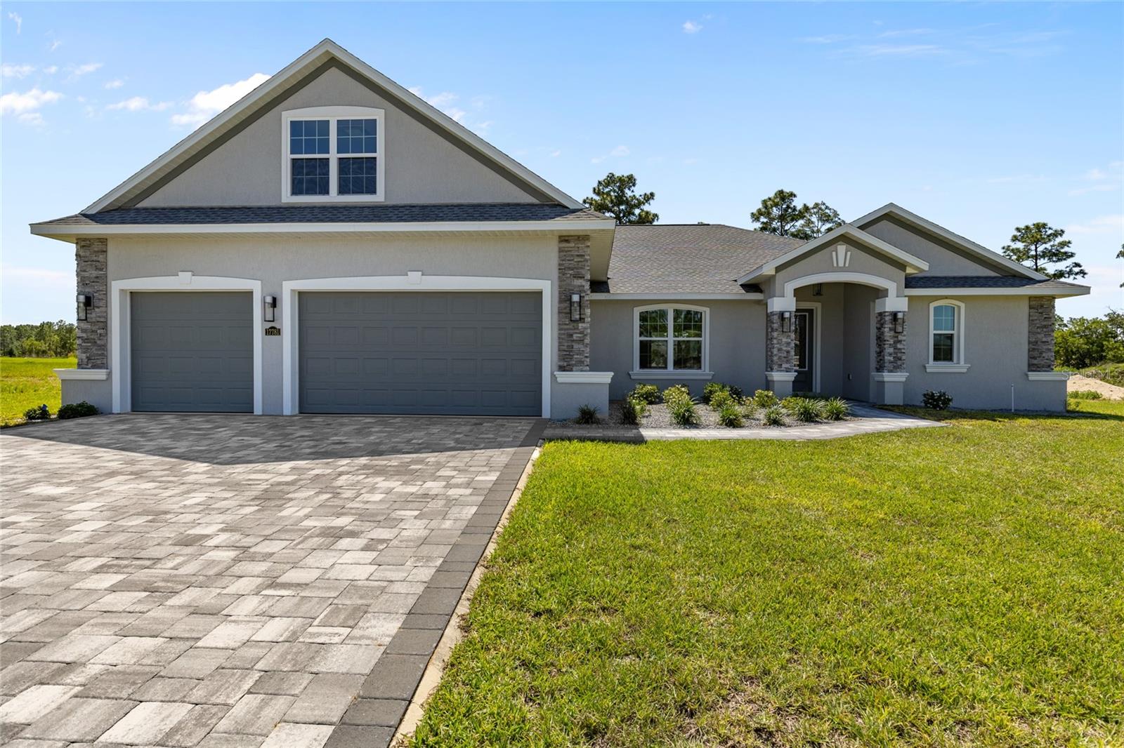 New Construction Beauty!! Welcome to Juliette Falls - a gated championship golf course community! Step inside and enter a Great Room with raised coffered ceilings, Luxury Vinyl Plank flooring, a modern linear fireplace wall with bench seating, and a three panel pocket sliding door. The massive kitchen is like something out of a magazine! Boasting wood cabinetry, a full wet bar with beverage fridge, and a custom 15’ island with a large kitchen sink, lots of cabinet storage, and bar seating area. The split floor plan ensures privacy in the primary wing which boasts a spa like bathroom with two vanities, a floor to ceiling tiled shower with two shower systems, two walk in closets, and a king sized bedroom with raised ceilings, a private sitting area, and a door with built in blinds leading to the covered lanai. Across the home, you’ll find 3 additional large bedrooms on the ground floor, all with access to beautifully designed bathrooms with unique features like fluted frameless shower glass. Upstairs you’ll find a bonus room / 5th bedroom with an en suite bathroom and spacious closet. The oversized laundry / mud room leads to the massive 3 car garage and expansive paver driveway. The covered lanai with Master Spas therapeutic hot tub awaits you, along with an enlarged paver patio ready for your outdoor kitchen design. There are truly too many upgrades to list. Do not miss seeing this one!! ***Owner financing an option for qualified buyers*** Located in the heart of Dunnellon, Juliette Falls is home to a top-rated public golf course and a clubhouse with a full-service restaurant. The community is ideally situated near the crystal-clear waters of the Rainbow River and the Withlacoochee River, offering easy access to kayaking, fishing, boating, and paddleboarding. You're also just minutes from historic downtown Dunnellon, with charming shops, and convenient stores like Publix, Aldi, Ace Hardware, Dollar Tree, along with many dining options. This prime Central Florida location places you within easy reach of the Gulf, Ocala’s renowned World Equestrian Center, Crystal River, Cedar Key, Gainesville, and is about 20 minutes from Ocala and hospitals/healthcare, and just about two hours from both Tampa and Orlando. Whether you're into golfing, biking, hiking, camping, horseback riding, or simply enjoying the Florida sunshine, this home offers the ultimate lifestyle in one of the state's most beautiful settings.