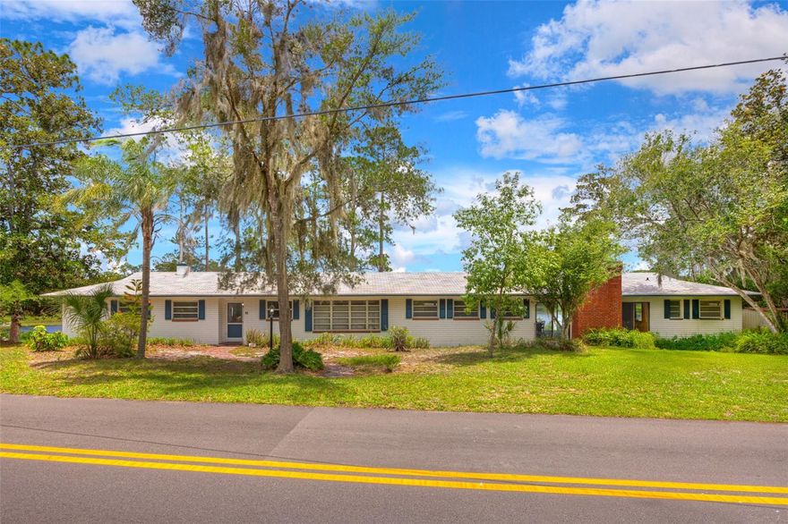 LAKEFRONT - DELAND - Lake Byron is calling! Picture yourself waking up every morning to private lake views stretching across the water—and then picture doing it from five bedrooms in a home you built exactly the way you imagine it. This solid masonry block home in Magnolia Shores sits on over 100 feet of private lake frontage on one of DeLand's most coveted bodies of water. At 2,752 square feet on a single level, there is room to design every corner. Original hardwood floors are throughout the house with some carpeted rooms. With lake views from virtually every room in the house, the canvas could not be more compelling. Three full bathrooms mean guests won't ever have to wait their turn. The screened in brick porch alone is worth the visit—288 square feet of waterfront entertaining space just waiting to be brought back to life. The backyard is peaceful and ready for those summer parties ahead. The roof was replaced in 2014, the HVAC in 2017, and a new water softener was installed in 2024. It includes a private well, two septic systems, and a wood-burning fireplace. The home is inviting and takes you back in time. Sold strictly as-is. Cash or conventional financing only. Schedule your showing and start dreaming. **MLS Info is intended to be correct but is not guaranteed and all information must be verified by buyers.**