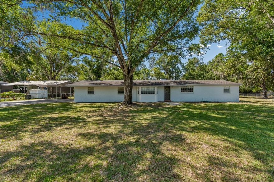 Beautiful and peaceful home nestled in the heart of Lutz! Mature trees surround this expansive, fully fenced yard—nearly a full acre—offering both privacy and space to enjoy.  This 4-bedroom, 2-bath, 2-car garage home features hardwood floors and a range of thoughtful upgrades, including a water softener, hydrogen peroxide water treatment system, and a reverse osmosis system at the kitchen sink. All appliances are included, making this home truly move-in ready. The spacious family room boasts a cozy wood-burning fireplace, perfect for relaxing evenings at home.  The oversized garage includes an A/C window unit, making it ideal for a workshop, hobby space, or additional comfort year-round. Enjoy the freedom of no HOA or CDD. Conveniently located with easy access to the Suncoast Parkway and I-75, this home offers a quick commute to wherever you need to go. You'll also be just minutes from shopping, dining, hospitals, and more!