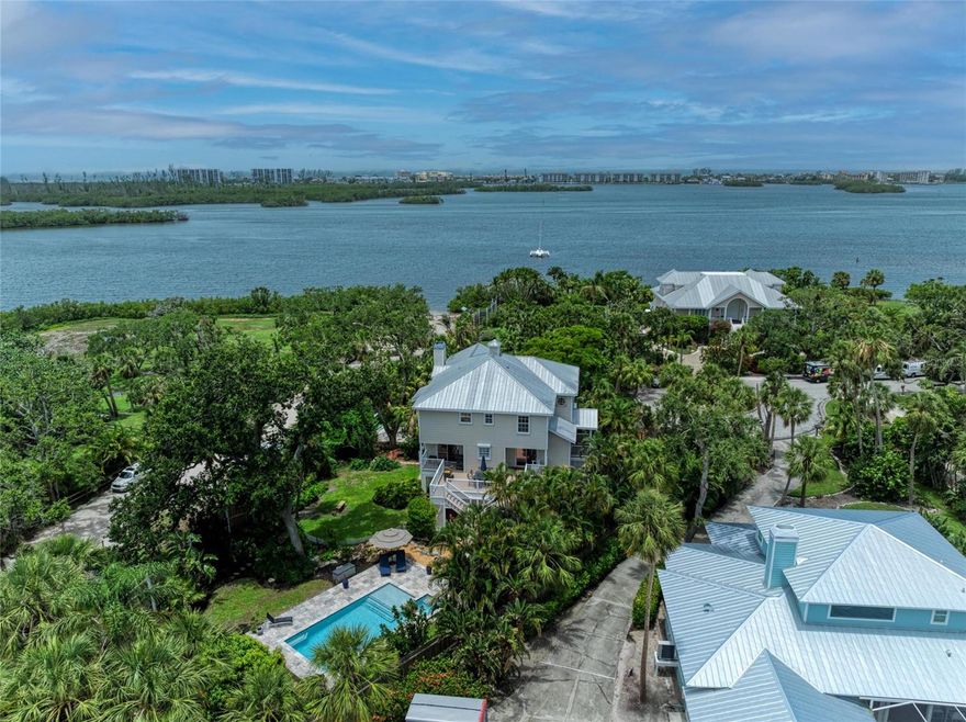 Live the Dream in Fishermen’s Bay – Private Bayfront Paradise with Deeded Boat Slip & Designer Touches. Welcome to a rare opportunity in the exclusive gated enclave of Fishermen’s Bay, a serene waterfront community of just 20 custom luxury homes, perfectly situated West of the Trail on the shimmering shores of Little Sarasota Bay. Tucked away at the end of a quiet cul-de-sac and nestled on a lush half-acre tropical estate, this Key West-style masterpiece offers over 3,200 square feet of elegant indoor living and expansive outdoor spaces designed for the ultimate Florida lifestyle. Enjoy Sarasota Bay views, water access, and a deeded boat slip, and private gate leading to Vamo Park for easy kayak launching just steps away. Crafted by renowned Yoder Construction, the home is a stunning blend of craftsmanship, comfort, and coastal sophistication. Step inside to discover wood floors, crown moldings, and stone countertops throughout. The chef’s kitchen is a dream, featuring a Viking range, Sub-Zero refrigerator, Fisher & Paykel dishwasher, quartz countertops ideal for entertaining. The main living and dining area opens through sets of French doors to a screened-in deck where you can relax and soak in the tranquil views of the bay and your private heated pool with sun shelf and 5-person spa (installed in 2020). Whether you’re enjoying your morning coffee or hosting sunset dinners, the setting is simply magical. The 3rd-floor master suite is a private sanctuary complete with a fireplace, dual walk-in closets, updated spa bath, and a private balcony offering serene water views.  On the ground floor, a large bonus area opens to lush, Selby Garden-style landscaping with rambling paver walkways, and plenty of storage for kayaks and beach toys. Enjoy peace of mind with electric hurricane shutters, a 3-zone A/C system, engineered walls, and a sprinkler system fed by your own well.
Additional Highlights:
 • Deeded boat slip with quick access to the Intracoastal
 • kayak launch
 • 2 fireplaces
 • Screened and covered porches for year-round enjoyment
 • 2-car garage with ample storage
 • Minutes to Siesta Key Beach, Pine View School, shopping, and dining
This is more than a home—it’s a lifestyle. Discover the timeless charm of Old Florida with every modern luxury you could desire. Paradise is calling in Fishermen’s Bay!
