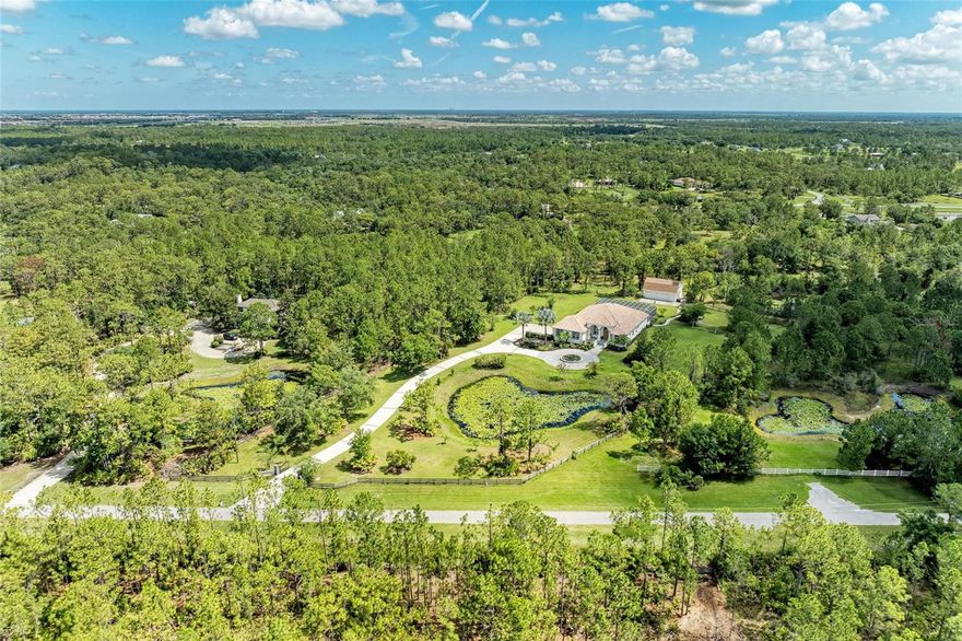 Welcome home to this elegantly REMODELED custom estate set on 5 private acres in the highly desired, equestrian-friendly community of The Forest at Panther Ridge! The Forest is 1 of 9 sections within Panther Ridge encompassing approximately 4,500 acres & 15 miles of scenic trails perfect for hiking or horseback riding. This stunning estate sits on 5 fenced acres consisting of towering pines, oak trees and two ponds on a private, dead-end street. This 3,890 square foot luxuriously REMODELED home has exceptional custom details throughout PLUS a 7 CAR GARAGE (4 car attached to main home & a 3 car detached garage)! The 3 car detached garage has a finished interior complete with spray foam insulation, drywall and paint. UPSTAIRS is a bonus/theatre room providing an EXTRA 595 sq ft., of living space. Dual-Head Mini Split AC system services both the garage area & upstairs bonus room. ALL GARAGE DOORS are MyQ enabled & can be opened & closed with the APP from anywhere! THIS gorgeous home includes 5 bedrooms, 4.5 bathrooms, two of the guest bedrooms are ensuites, a large covered lanai area with a HUGE pool & spa perfect for entertaining & a newer paver walkway leading you to the firepit area & detached garage space. Upon entering the grand foyer you are taken back by the custom details with 14 foot ceilings in the entry and primary bedroom and 12 foot ceilings throughout the rest of the home, elegant columns, tray ceilings and a direct view of the pool area through the 4 large, pocketing sliders. The stunning AND extensive high-end kitchen remodel done in 2021 will take your breath away with no expense spared! Gorgeous 42" white, dove-tailed, soft-close cabinets, GORGEOUS MARBLE TOPS, two islands one being a HUGE family-style island with seating, custom-carved decorative legs & tons of under-counter storage all push to open/close. Franke faucet and Franke fragranite sink which is an exceptionally tough material highly resistant to burns, dents, chips & stains. GE luxury-line Cafe Series appliances including two wall ovens with multi-level convection & one with French door. ALL Cafe Appliances are App enabled & can set custom routines, such as having range hood turn on & off with cooktop. Cooktop is Bluetooth enabled allowing communication with Heat Cue Smart Cookware on the App. You will appreciate the LARGE, DESIGNER lights over the island bringing warmth and elegance to this space. OTHER UPDATES & FEATURES: Tray ceilings, crown molding. 2021: NEW high-end Mannington luxury-vinyl flooring & NEW designer lighting throughout. Guest bath renovations: NEW vanities, tops, faucets, & lighting. NEW fire pit & paver path, NEW Westinghouse/HTP Lifetime stainless steel water heater. 2025: NEW front porch anti-slip tile & NEW painted lanai. NEW pool salt cell & wireless Pentair pool controller. 2023: New pool pump. 2022: NEWLY painted house & detached garage exterior, NEW well pressure switch. 2020: NEW 2.5 ton A/C main house, NEW window balances & locks, wireless irrigation system. 2019: NEW house garage door openers. THIS PEACEFUL & PRIVATE COUNTRY LOCATION is ONLY minutes to Lakewood Ranch, shopping, dining, LWR Hospital, UTC Mall, Waterside & A-Rated Lakewood Ranch schools! A short drive to our area's beautiful beaches & airports! This elegantly remodeled country estate perfectly combines exceptional custom features with a PRIME LOCATION! Come fall in love with this beautiful estate in the highly-desirable Panther Ridge community!