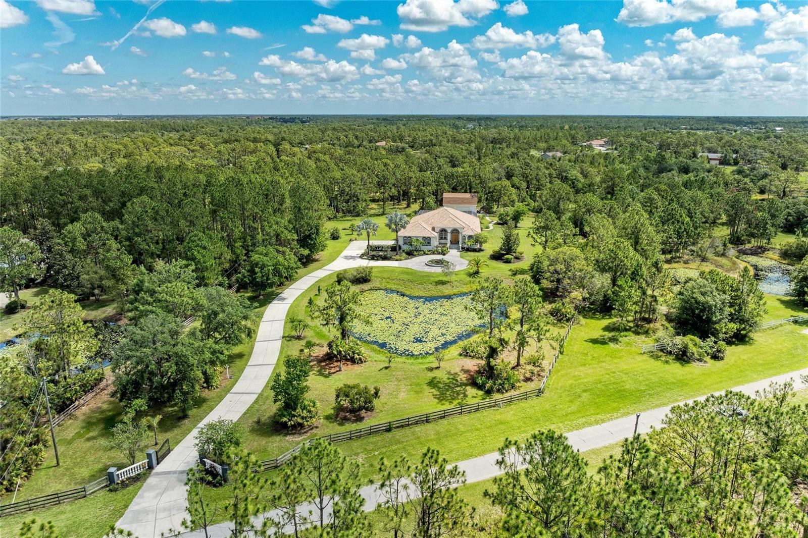 Welcome home to this elegantly REMODELED custom estate set on 5 private acres in the highly desired, equestrian-friendly community of The Forest at Panther Ridge! The Forest is 1 of 9 sections within Panther Ridge encompassing approximately 4,500 acres & 15 miles of scenic trails perfect for hiking or horseback riding. This stunning estate sits on 5 fenced acres consisting of towering pines, oak trees and two ponds on a private, dead-end street. This 3,890 square foot luxuriously REMODELED home has exceptional custom details throughout PLUS a 7 CAR GARAGE (4 car attached to main home & a 3 car detached garage)! The 3 car detached garage has a finished interior complete with spray foam insulation, drywall and paint. UPSTAIRS is a bonus/theatre room providing an EXTRA 595 sq ft., of living space. Dual-Head Mini Split AC system services both the garage area & upstairs bonus room. ALL GARAGE DOORS are MyQ enabled & can be opened & closed with the APP any time, anywhere! THIS gorgeous home includes 5 bedrooms, 4.5 bathrooms, two of the guest bedrooms are ensuites, a large covered lanai area with a HUGE pool and spa perfect for entertaining and a newer paver walkway leading you to the firepit area & detached garage space. Upon entering the grand foyer you are taken back by the custom details with 14 foot ceilings in the entry and primary bedroom and 12 foot ceilings throughout the rest of the home, elegant columns, tray ceilings and a direct view of the pool area through the 4 large, pocketing sliders. The stunning AND extensive high-end kitchen remodel done in 2021 will take your breath away with no expense spared! Gorgeous 42" white, dove-tailed, soft-close cabinets, GORGEOUS MARBLE TOPS, two islands one being a HUGE family-style island with seating, custom-carved decorative legs & tons of under-counter storage all push to open/close. Franke faucet and Franke fragranite sink which is an exceptionally tough material highly resistant to burns, dents, chips & stains. GE luxury-line Cafe Series appliances including two wall ovens with multi-level convection & one with French door. ALL Cafe Appliances are App enabled & can set custom routines, such as having range hood turn on & off with cooktop. Cooktop is Bluetooth enabled allowing communication with Heat Cue Smart Cookware on the App. You will appreciate the LARGE, DESIGNER lights over the island bringing warmth and elegance to this space. OTHER UPDATES & FEATURES: Tray ceilings, crown molding. 2021: NEW high-end Mannington luxury-vinyl flooring & NEW designer lighting throughout. Guest bath renovations: NEW vanities, tops, faucets, & lighting. NEW fire pit & paver path, NEW Westinghouse/HTP Lifetime stainless steel water heater. 2025: NEW front porch anti-slip tile & NEW painted lanai. NEW pool salt cell & wireless Pentair pool controller. 2023: New pool pump. 2022: NEWLY painted house & detached garage exterior, NEW well pressure switch. 2020: NEW 2.5 ton A/C main house, NEW window balances & locks, wireless irrigation system. 2019: NEW house garage door openers. THIS PEACEFUL & PRIVATE COUNTRY LOCATION is ONLY minutes to Lakewood Ranch, shopping, dining, LWR Hospital, UTC Mall, Waterside & A-Rated Lakewood Ranch schools! A short drive to our area's beautiful beaches and airports! This elegantly remodeled country estate perfectly combines exceptional custom features with a PRIME LOCATION! Come fall in love with this beautiful estate in the highly-desirable Panther Ridge community!