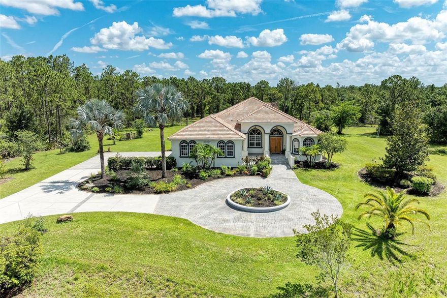 Welcome home to this elegantly REMODELED custom estate set on 5 private acres in the highly desired, equestrian-friendly community of The Forest at Panther Ridge! The Forest is 1 of 9 sections within Panther Ridge encompassing approximately 4,500 acres & 15 miles of scenic trails perfect for hiking or horseback riding. This stunning estate sits on 5 fenced acres consisting of towering pines, oak trees and two ponds on a private, dead-end street. This 3,890 square foot luxuriously REMODELED home has exceptional custom details throughout PLUS a 7 CAR GARAGE (4 car attached to main home & a 3 car detached garage)! The 3 car detached garage has a finished interior complete with spray foam insulation, drywall and paint. UPSTAIRS is a bonus/theatre room providing an EXTRA 595 sq ft., of living space. Dual-Head Mini Split AC system services both the garage area & upstairs bonus room. ALL GARAGE DOORS are MyQ enabled & can be opened & closed with the APP from anywhere! THIS gorgeous home includes 5 bedrooms, 4.5 bathrooms, two of the guest bedrooms are ensuites, a large covered lanai area with a HUGE pool & spa perfect for entertaining & a newer paver walkway leading you to the firepit area & detached garage space. Upon entering the grand foyer you are taken back by the custom details with 14 foot ceilings in the entry and primary bedroom and 12 foot ceilings throughout the rest of the home, elegant columns, tray ceilings and a direct view of the pool area through the 4 large, pocketing sliders. The stunning AND extensive high-end kitchen remodel done in 2021 will take your breath away with no expense spared! Gorgeous 42" white, dove-tailed, soft-close cabinets, GORGEOUS MARBLE TOPS, two islands one being a HUGE family-style island with seating, custom-carved decorative legs & tons of under-counter storage all push to open/close. Franke faucet and Franke fragranite sink which is an exceptionally tough material highly resistant to burns, dents, chips & stains. GE luxury-line Cafe Series appliances including two wall ovens with multi-level convection & one with French door. ALL Cafe Appliances are App enabled & can set custom routines, such as having range hood turn on & off with cooktop. Cooktop is Bluetooth enabled allowing communication with Heat Cue Smart Cookware on the App. You will appreciate the LARGE, DESIGNER lights over the island bringing warmth and elegance to this space. OTHER UPDATES & FEATURES: Tray ceilings, crown molding. 2021: NEW high-end Mannington luxury-vinyl flooring & NEW designer lighting throughout. Guest bath renovations: NEW vanities, tops, faucets, & lighting. NEW fire pit & paver path, NEW Westinghouse/HTP Lifetime stainless steel water heater. 2025: NEW AC Unit, NEW front porch anti-slip tile & NEW painted lanai. NEW pool salt cell & wireless Pentair pool controller. 2023: New pool pump. 2022: NEWLY painted house & detached garage exterior, NEW well pressure switch. 2020: NEW 2.5 ton A/C main house, NEW window balances & locks, wireless irrigation system. 2019: NEW house garage door openers. THIS PEACEFUL & PRIVATE COUNTRY LOCATION is ONLY minutes to Lakewood Ranch, shopping, dining, LWR Hospital, UTC Mall, Waterside & A-Rated Lakewood Ranch schools! A short drive to our area's beautiful beaches & airports! This elegantly remodeled country estate perfectly combines exceptional custom features with a PRIME LOCATION! Come fall in love with this beautiful estate in the highly-desirable Panther Ridge community!