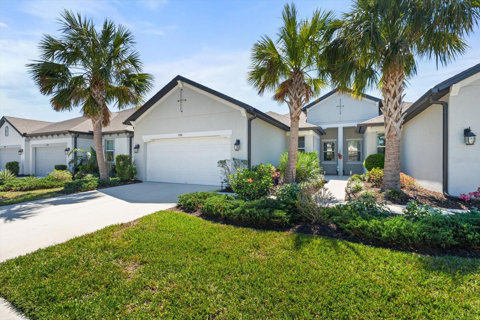 Welcome to Amberly, a gated community offering maintenance-free living. This move-in-ready 2-bedroom, 2-bathroom villa includes a den/office and a 2-car garage. The sellers have partially turn-key furnished the property incase a buyer would like the items to stay as a convenience. Step inside to a foyer that opens into a spacious living area with high ceilings and ceramic tile throughout the main living spaces, with carpet in the bedrooms. The den, with double doors, can be used as an office, hobby room, or even a third bedroom. The kitchen features white cabinets with crown molding, quartz countertops, stainless steel appliances, and a walk-in pantry. A screened-in lanai overlooks a private backyard, perfect for relaxation. The primary suite includes an ensuite bathroom with a double vanity, granite countertops, a tiled shower with glass doors, and a walk-in closet. A second bedroom, full bathroom with a walk-in shower, and linen closet are centrally located. An indoor laundry room with storage shelving sits off the kitchen and leads to a 2-car garage with epoxy flooring, additional storage, and a small workshop area. Located less than two miles from I-75, this home offers easy access to all that Florida has to offer. Relax by the community pool, enjoy picturesque lake views, and embrace the low-HOA, no-CDD, maintenance-free lifestyle. Make this beautiful villa your Florida retreat today!
