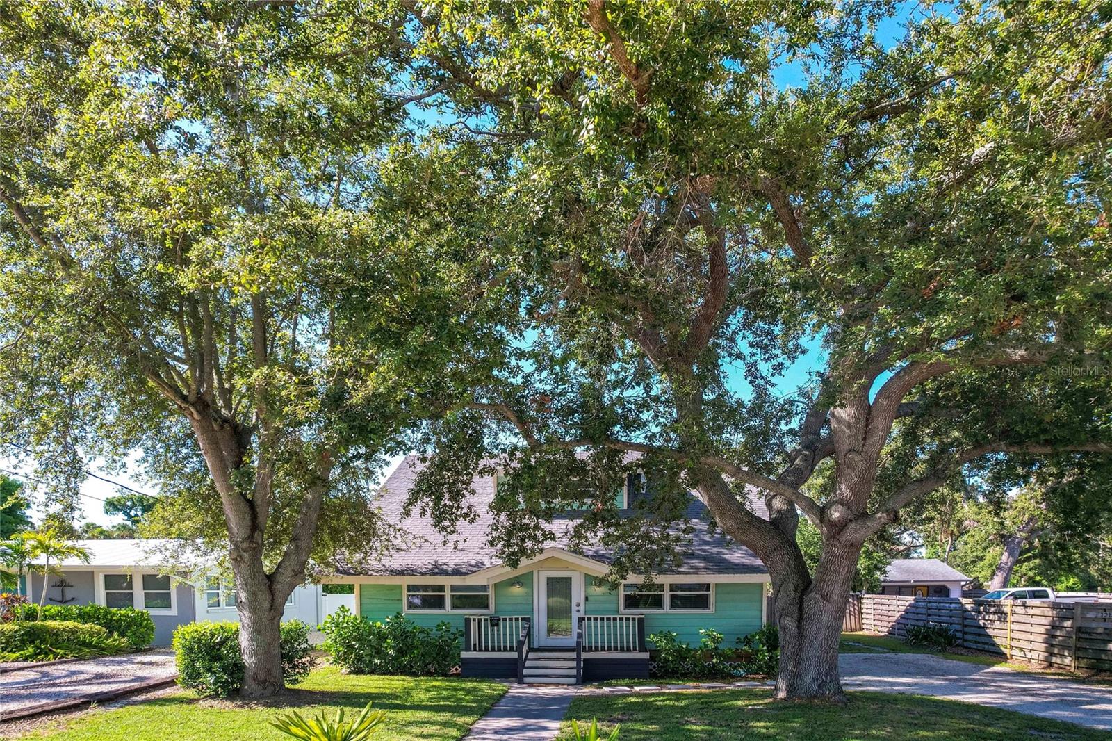 Step back in time without sacrificing modern comfort in this beautifully updated 1911 bungalow nestled in the heart of Palmetto’s historic district. This charming 2-story home offers 3 bedrooms, 2.5 bathrooms, and over 2,100 square feet of thoughtfully designed living space—all within walking distance to the scenic Regatta Pointe Marina, where oak-canopied streets and waterfront dining create the perfect backdrop for evening strolls. A welcoming front porch invites you to slow down and enjoy the charm of this timeless home. Inside, an open floorplan unfolds with luxury vinyl plank flooring throughout, setting the stage for a seamless blend of historic character and modern finishes. The fully renovated kitchen is a standout feature, showcasing butcher block countertops with barstool seating, a vent hood, and stylish cabinetry—perfect for casual dining or entertaining. A convenient half bath on the main floor offers a smart layout for guests. The expansive 390 sq ft primary suite is located on the first floor, offering privacy and retreat-like comfort. You’ll fall in love with the barn door entry to the spa-inspired ensuite bath, featuring a soaking tub, high-end shower system, a striking granite accent wall, and dual vanities. Upstairs, two generously sized bedrooms share a beautifully updated guest bathroom with dual vessel sinks and a modern stand-up shower. Outdoor living is just as impressive. A 325 sq ft screened-in porch is ideal for year-round enjoyment, complete with a pass-through from the kitchen for easy entertaining. The fully fenced backyard features a turf putting green, grilling area, and even space to park your boat—because with the Manatee River just minutes away, you’re never far from your next adventure on the Gulf. Additional highlights include a dedicated laundry room and the option to purchase furnished for an effortless move-in. US-41 is nearby for easy commuting, while Downtown Bradenton, Anna Maria Island, and the Ellenton Outlets are just a short drive away. Don’t miss the chance to own a piece of Palmetto history!