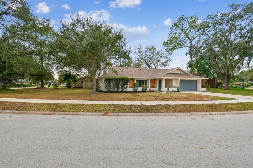 Nestled in the desirable Tarpon Woods golf course community in Palm Harbor, this beautifully updates 3-bedroom, 2-bath, 2-car garage home sits on an oversized corner lot and offers a spacious floor plan designed for both comfort and entertaining. The stunning kitchen features granite countertops, stainless steel appliances, ample cabinetry, eat-in kitchen area, and open to the living area. Luxury vinyl plank flooring runs throughout the home-no carpet-completed by new ceiling fans and lighting. The split-bedroom layout provides privacy, with a generous primary bedroom offering an en-suite bath, while the additional bedrooms are well-sized. Both bathrooms have been tastefully updated. The inside laundry room adds extra functionality. Step outside to the screened-in patio overlooking an ample backyard with plenty of room for a pool or create your own outdoor oasis. Roof is 2019, AC is 2018. Located in a sought-after school district and close to shopping, dining, and entertainment, the gulf beaches and Tampa International airport Approximately 30 minutes away. This home combines style, location, convenience in one exceptional package.