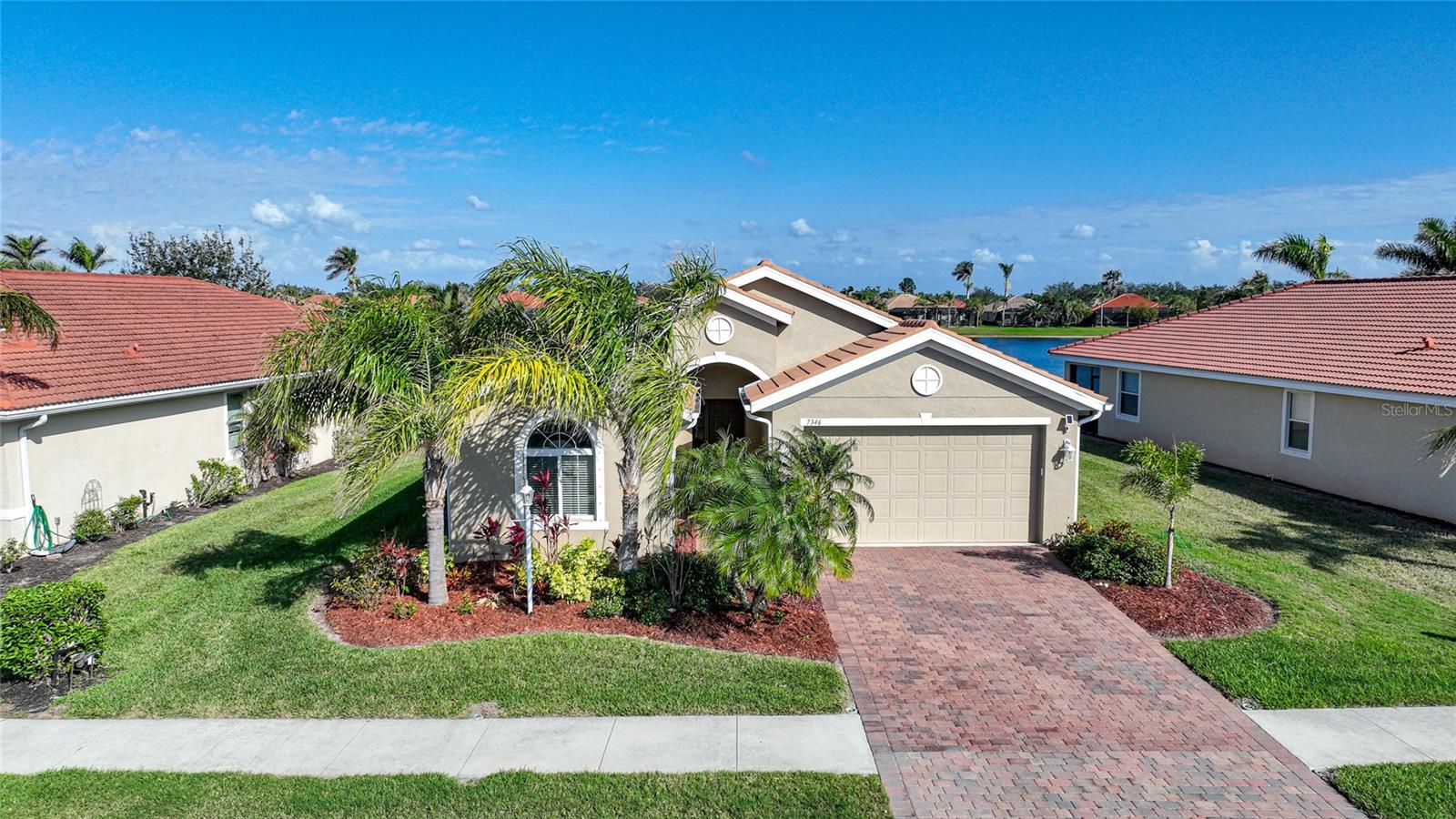 Welcome to the hidden gem of North Port – the exclusive, gated community of Talon Bay. NOT IN A FLOOD ZONE!! This immaculate waterfront home features an expansive open floor plan with 1,804 sq. ft. of living space and is located just 2 doors down from the clubhouse. As you approach, you’re greeted by meticulously manicured lawns and lush vegetation, setting the tone for the beauty that awaits inside. Located on a tranquil lakefront lot, this home offers stunning views of serene waters creating the perfect retreat for nature lovers and those seeking peace and privacy. Step out front of your home to another tranquil lake view that is unobstructed by neighbors! As you enter through the front door into the foyer that opens to a spacious living/dining area, where classic ceramic tile floors flow seamlessly throughout the living space. The kitchen is a chef’s dream, boasting granite countertops, a center island with pendant lighting, a suite of premium stainless steel appliances, and raised panel cabinetry with upper crown molding. A closet-style pantry ensures ample storage, while abundant windows and sliding glass doors leading to the lanai flood the space with natural light. The kitchen effortlessly flows into the great room and dining area, making this open-concept layout ideal for both entertaining and everyday living. The spacious primary suite is a true sanctuary with plush carpeting, a generous walk-in closet and built-in, an ensuite bath with a walk-in shower with frameless glass wall/door, relaxing soaking tub, dual sinks, and ample storage. This thoughtfully designed home also offers two versatile bedrooms and share a full guest bath. Outside the covered lanai, creates a perfect environment for alfresco dining, entertaining, or simply relaxing while enjoying the peaceful lake views. Additional features include a laundry room with utility sink and storage, a two-car garage, brick paver driveway/walkway, tile roof just cleaned, hurricane shutters and so much more. Talon Bay offers a gated entrance, a clubhouse, heated pool, fitness center, tennis courts, sidewalks, and a kayak/canoe launch. Conveniently located near I-75 and US-41, you’ll enjoy easy access to beaches, shopping, dining, and more. This lakefront oasis combines modern comforts, natural beauty, and thoughtful details, making it the perfect place to call home. Don’t miss the chance to own this remarkable property! Be sure to take the complimentary virtual tour.