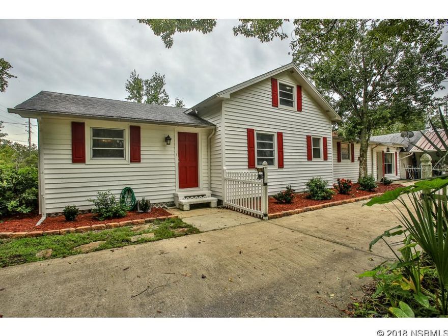 An unhurried, simple way of life is beckoning you.  And this charming home will start you on that path! From the white picket fence & cheerful red shutters & doors, it oozes "home"!  Custom wood cabinets, wood burning fireplace, some original wood floors, whimsical cow bell "doorbell"...to updated bathrooms, stainless steel appliances...Country meets City with 2 fenced acres just minutes from shopping & restaurants! Large utility room, screened porch overlooking pool. Bring your horses & kids! What are you waiting for??