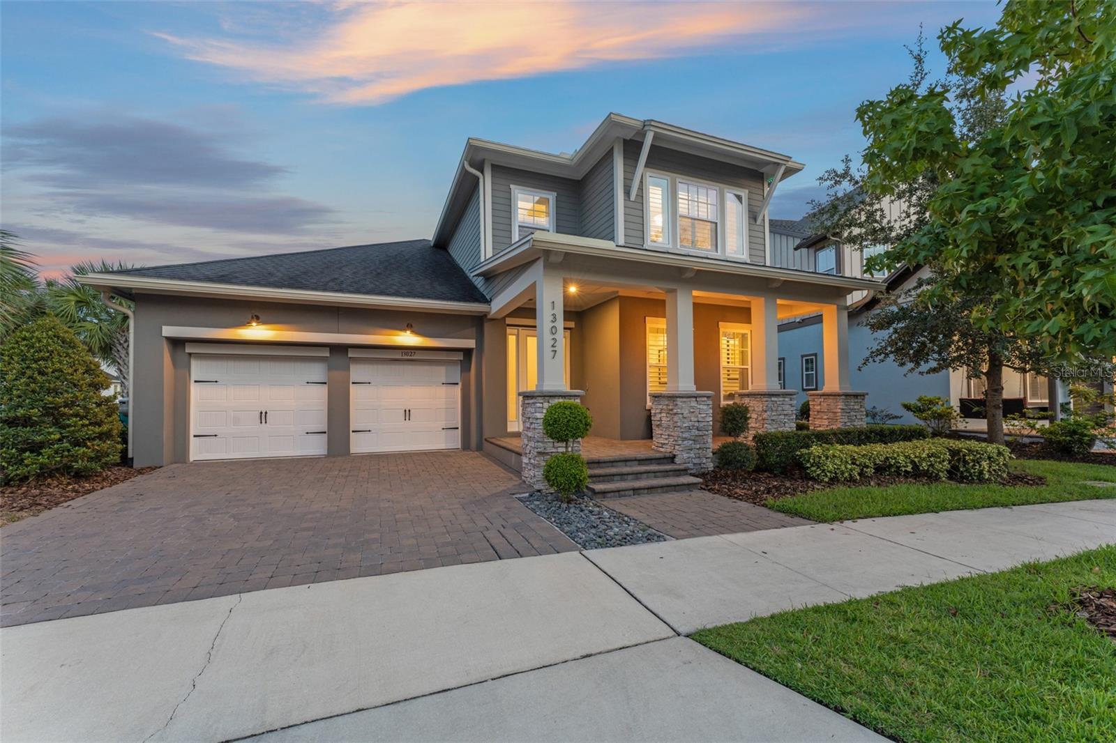 Welcome home to this rare 5-bedroom, 4 full, and 2 half bath water-view residence in highly sought-after Laureate Park, offering an oversized lot, resort-style backyard, and unbeatable location. This better-than-new 2019 David Weekley “Manville” boasts soaring 20’ ceilings, walls of windows, and sweeping water vistas. The open layout includes a first-floor owner’s retreat, private guest suite, office/den, and a gourmet kitchen with an oversized quartz island, GE Profile appliances, wine fridge, designer backsplash, and walk-in pantry.The owner’s suite showcases a fully remodeled spa bath with soaking tub, frameless rain shower, and custom closet. Interior upgrades include engineered wood floors throughout (no carpet), custom closet/pantry/mudroom build-outs, a remodeled laundry with hidden wine closet, and a striking built-in TV/fireplace wall in the living room. Added features include UV HVAC lights, custom garage storage, upgraded fixtures and hardware, gutters, and surround sound wiring. Step outside to your private retreat with a saltwater pool & spa, cabana with waterfall, sunken fire pit with built-in seating, fully covered outdoor kitchen, sandblasted marble decking, turfed yard, lush landscaping, and permanent gutter lighting. Walk to Canvas Restaurant, community pools, fitness, tennis, parks, and trails. Minutes to Medical City, USTA, Lake Nona Town Center, OIA, beaches, and theme parks. Don’t mis out on this incredible home, schedule your visit today.